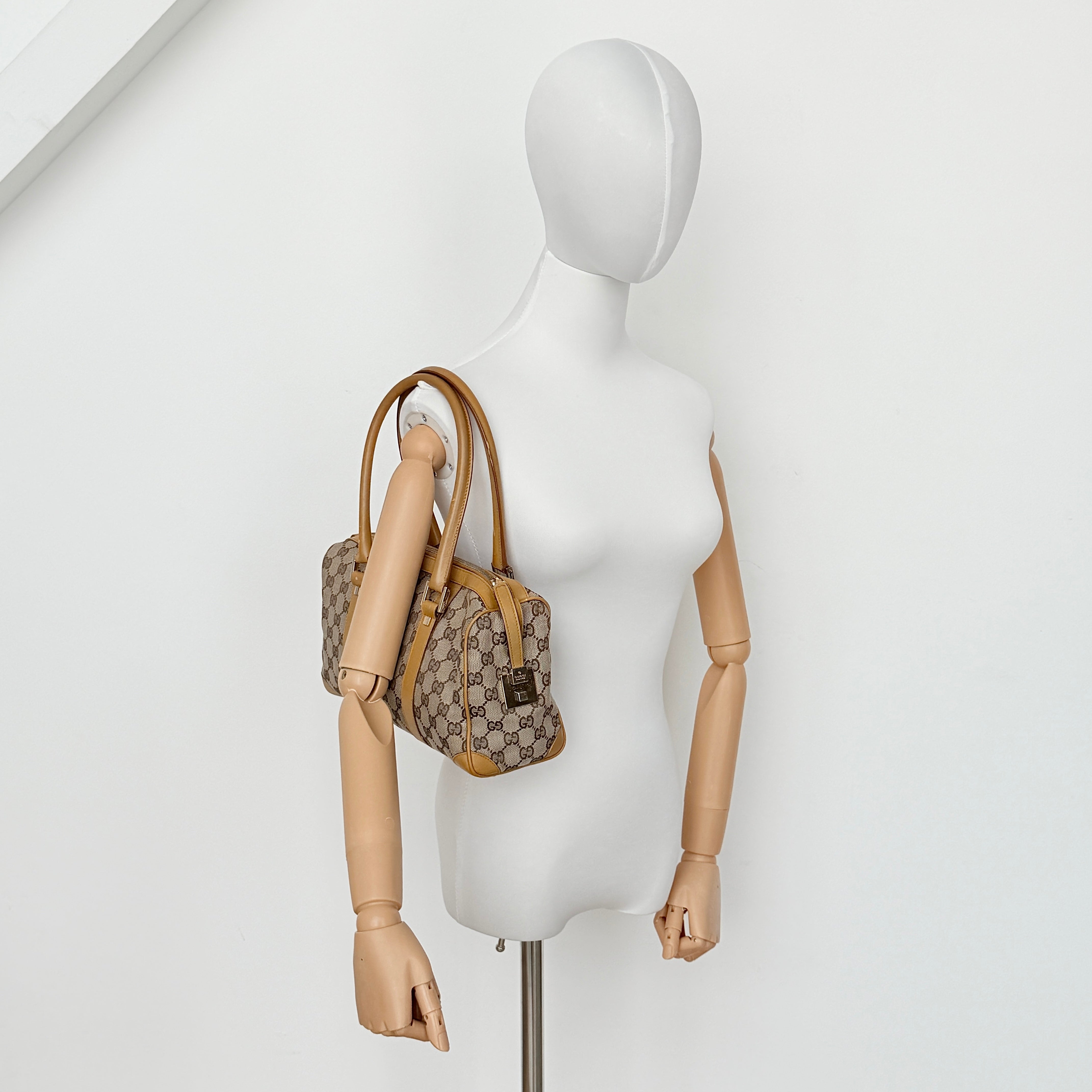 Gucci Abbey Mini Boston shoulder bag in beige GG monogram canvas with caramel leather trim and silver-tone hardware.