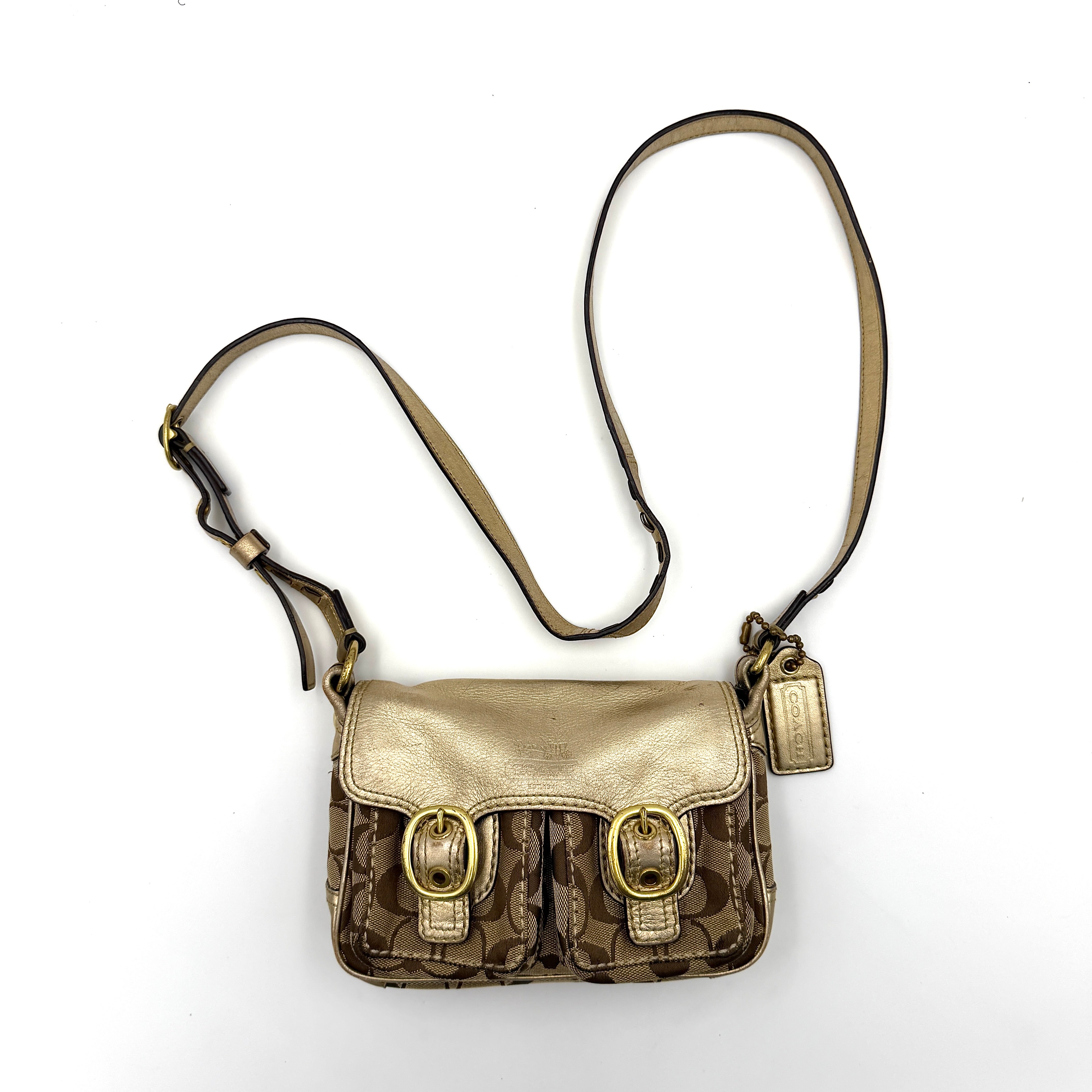 Coach Bleecker crossbody bag in gold metallic leather and beige monogram canvas with double front buckle details.