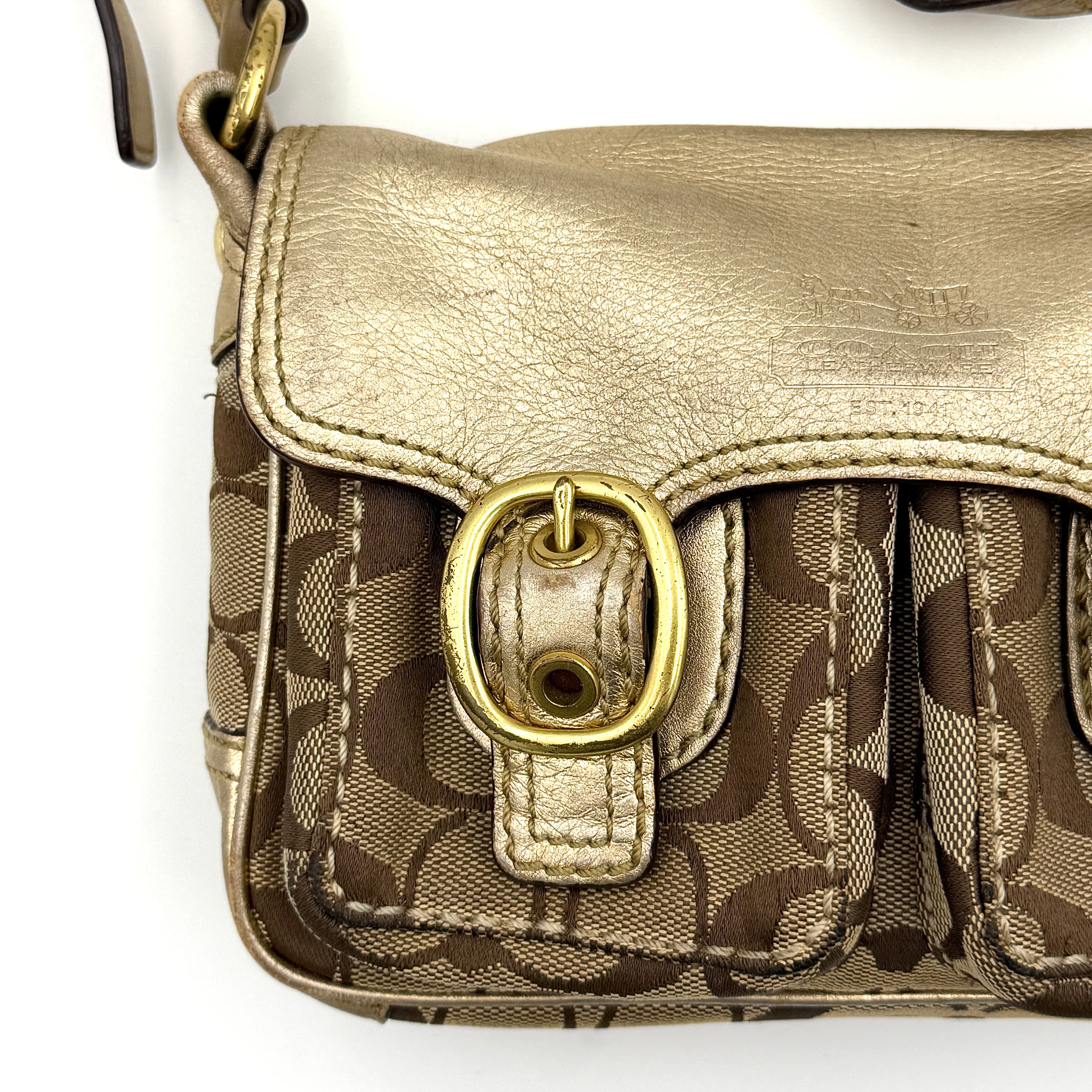 Coach Bleecker crossbody bag in gold metallic leather and beige monogram canvas with double front buckle details.
