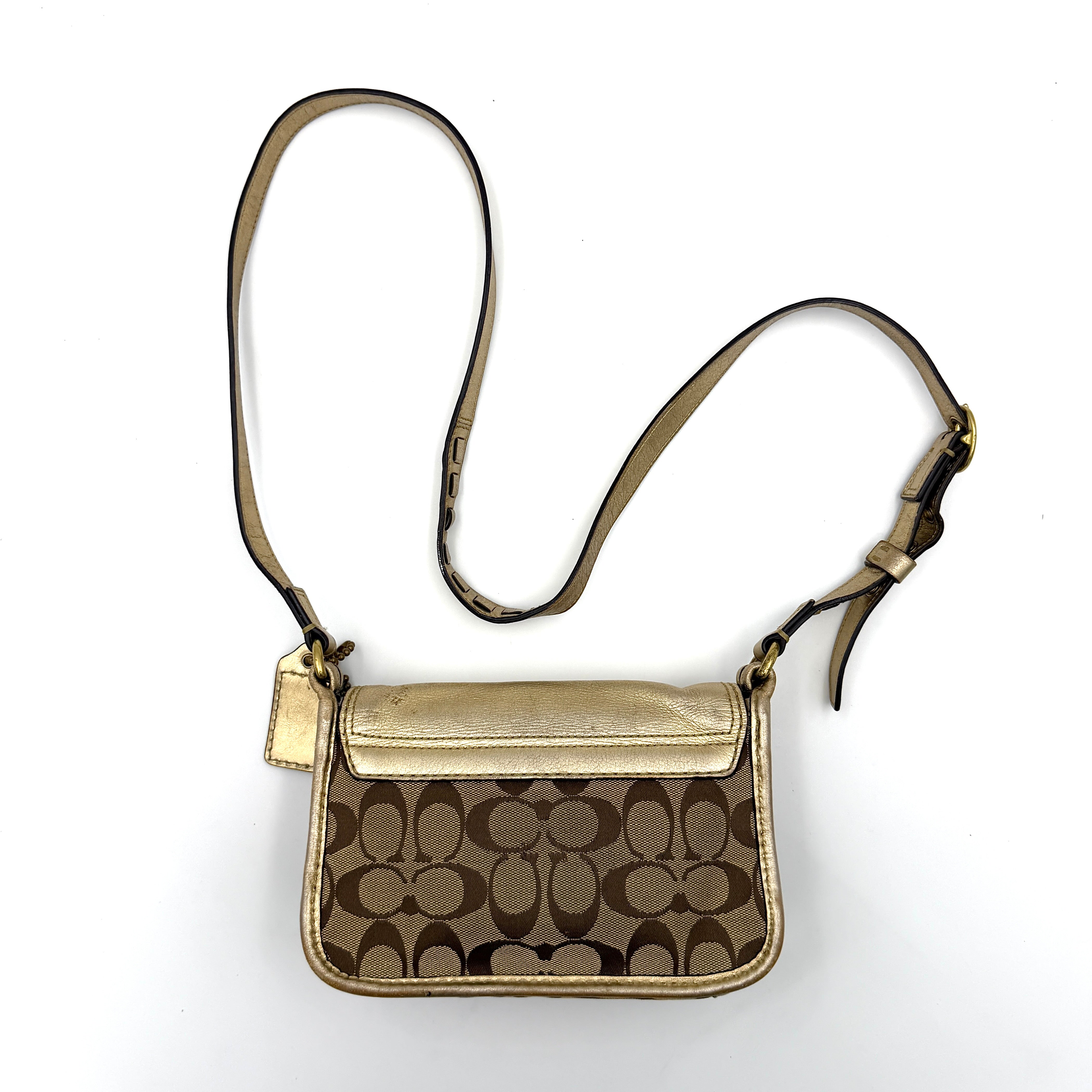 Coach Bleecker crossbody bag in gold metallic leather and beige monogram canvas with double front buckle details.