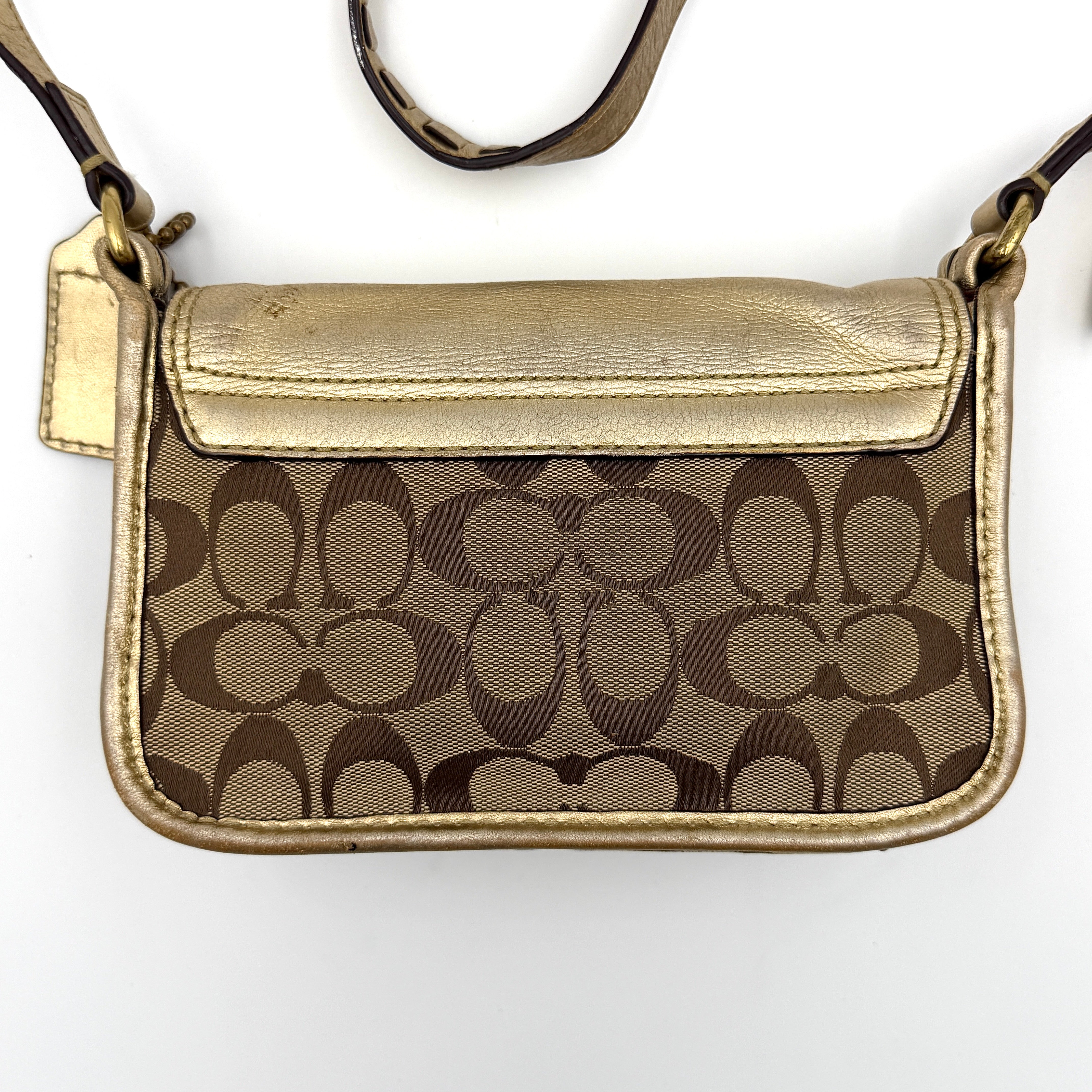 Coach Bleecker crossbody bag in gold metallic leather and beige monogram canvas with double front buckle details.