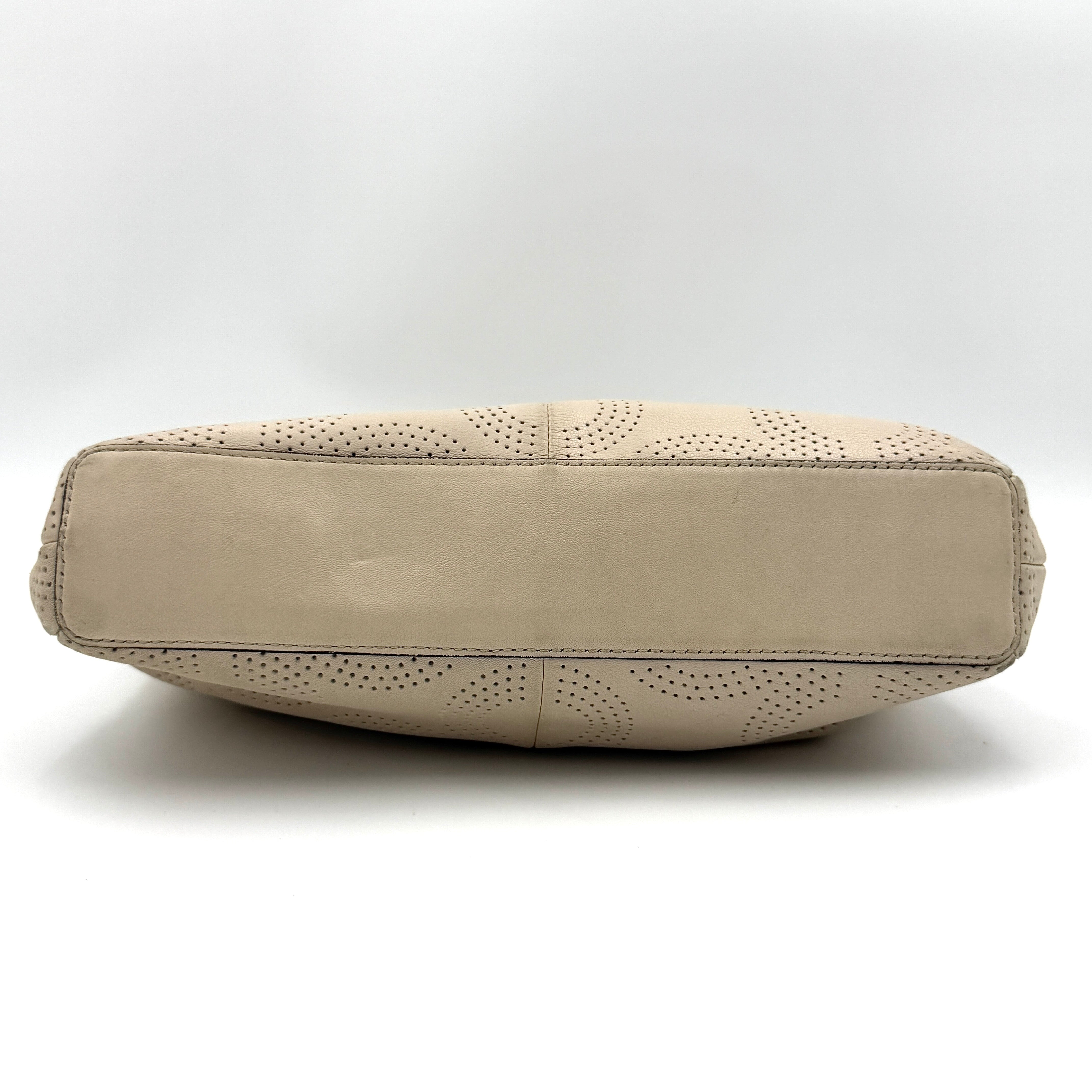 Coach Ashley 2Way cream perforated Op Art leather handbag with dual handles and detachable strap, styled on a white background.