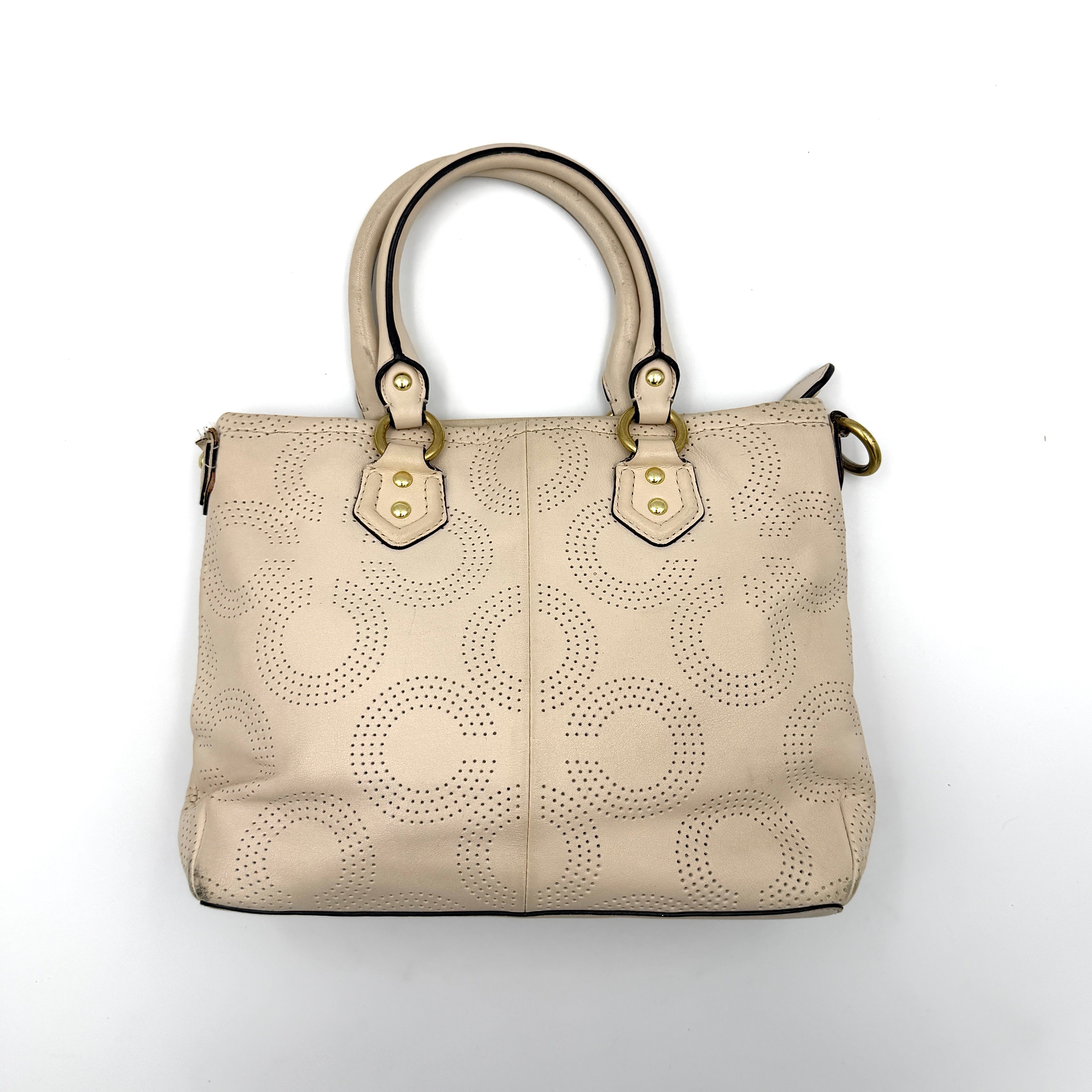 Coach Ashley 2Way cream perforated Op Art leather handbag with dual handles and detachable strap, styled on a white background.