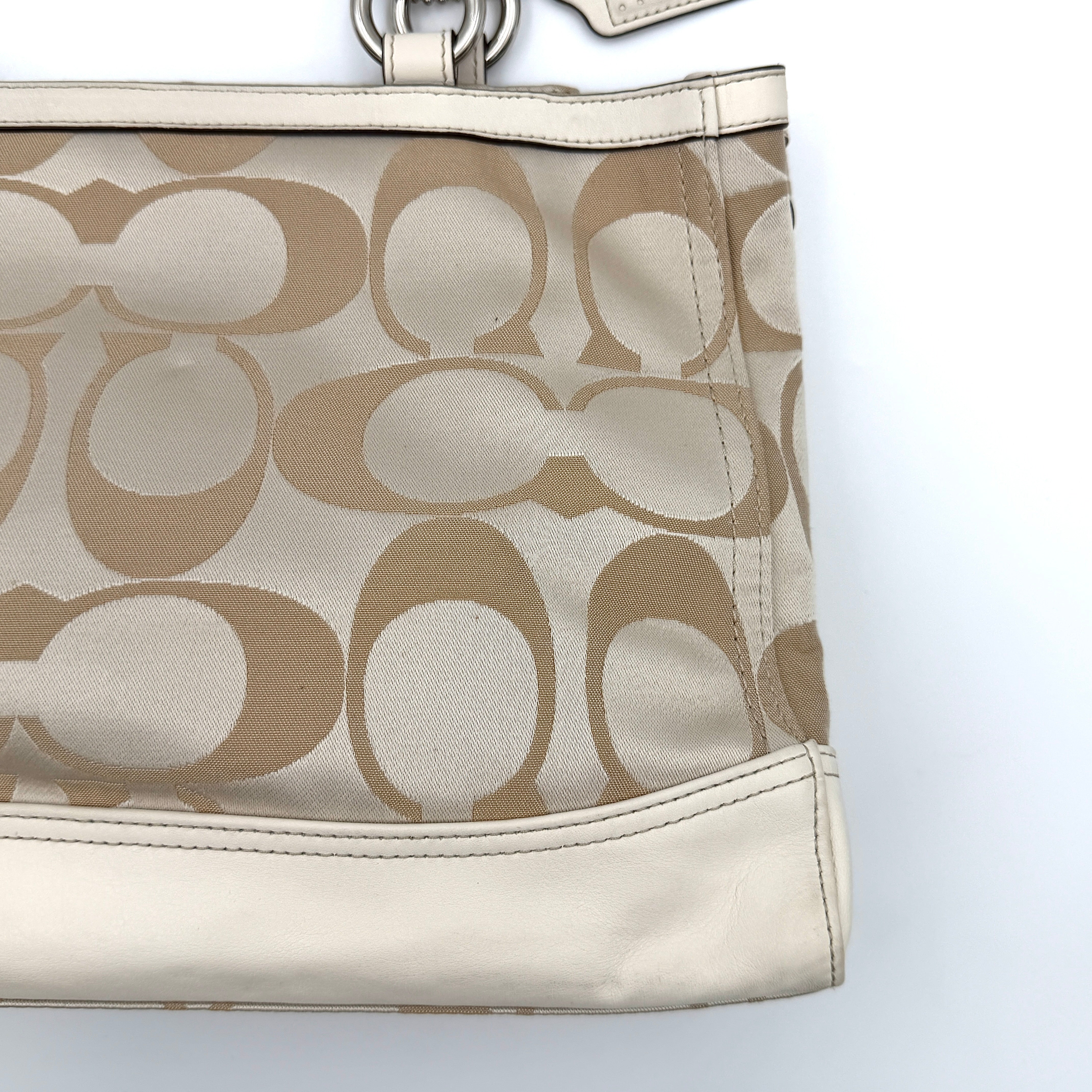 Coach Signature Carryall Shoulder Bag in beige jacquard canvas with cream leather trim and silver hardware displayed against a white background.