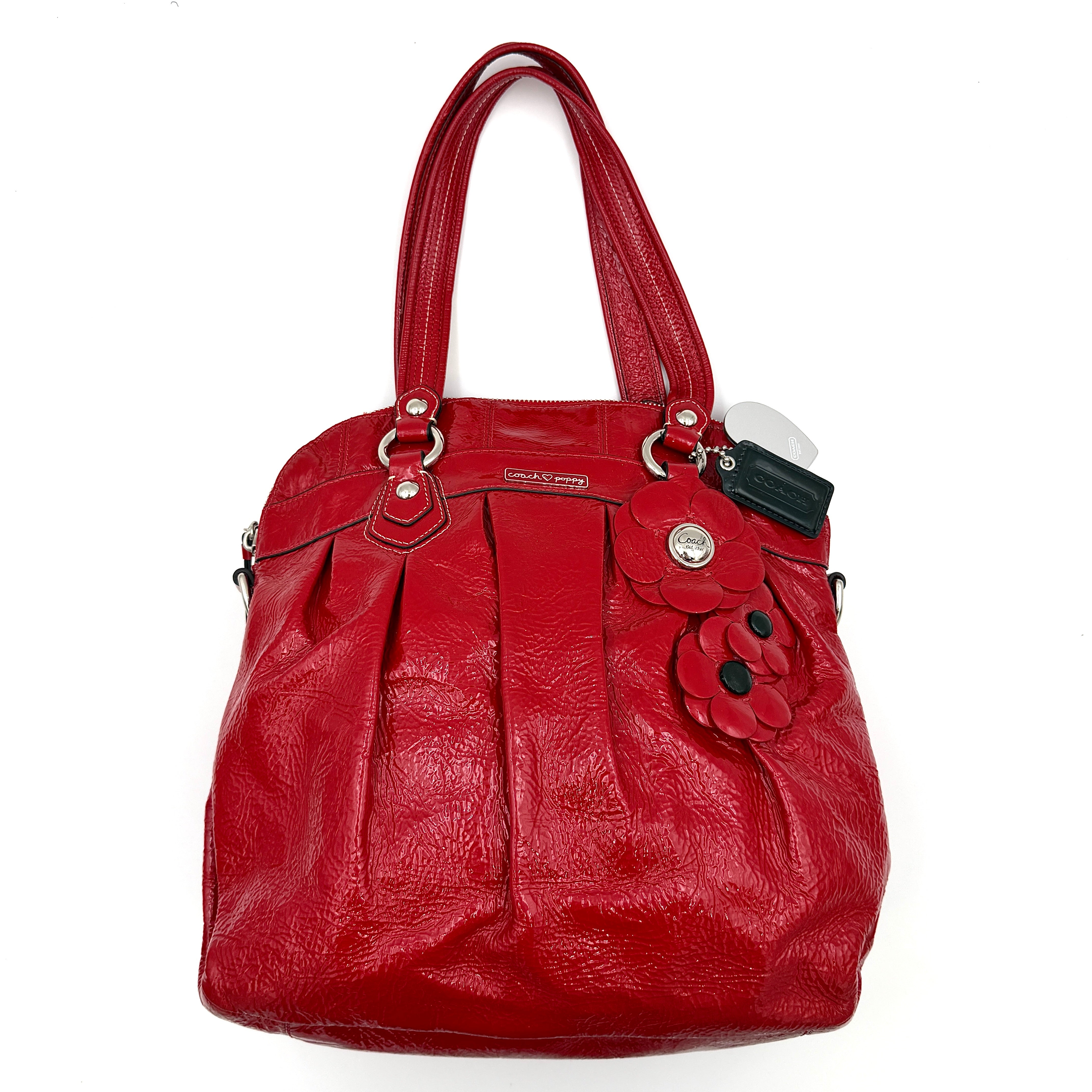 Coach Poppy 2Way shoulder bag in glossy red patent leather with floral appliqué, heart charm, double handles and detachable long strap.