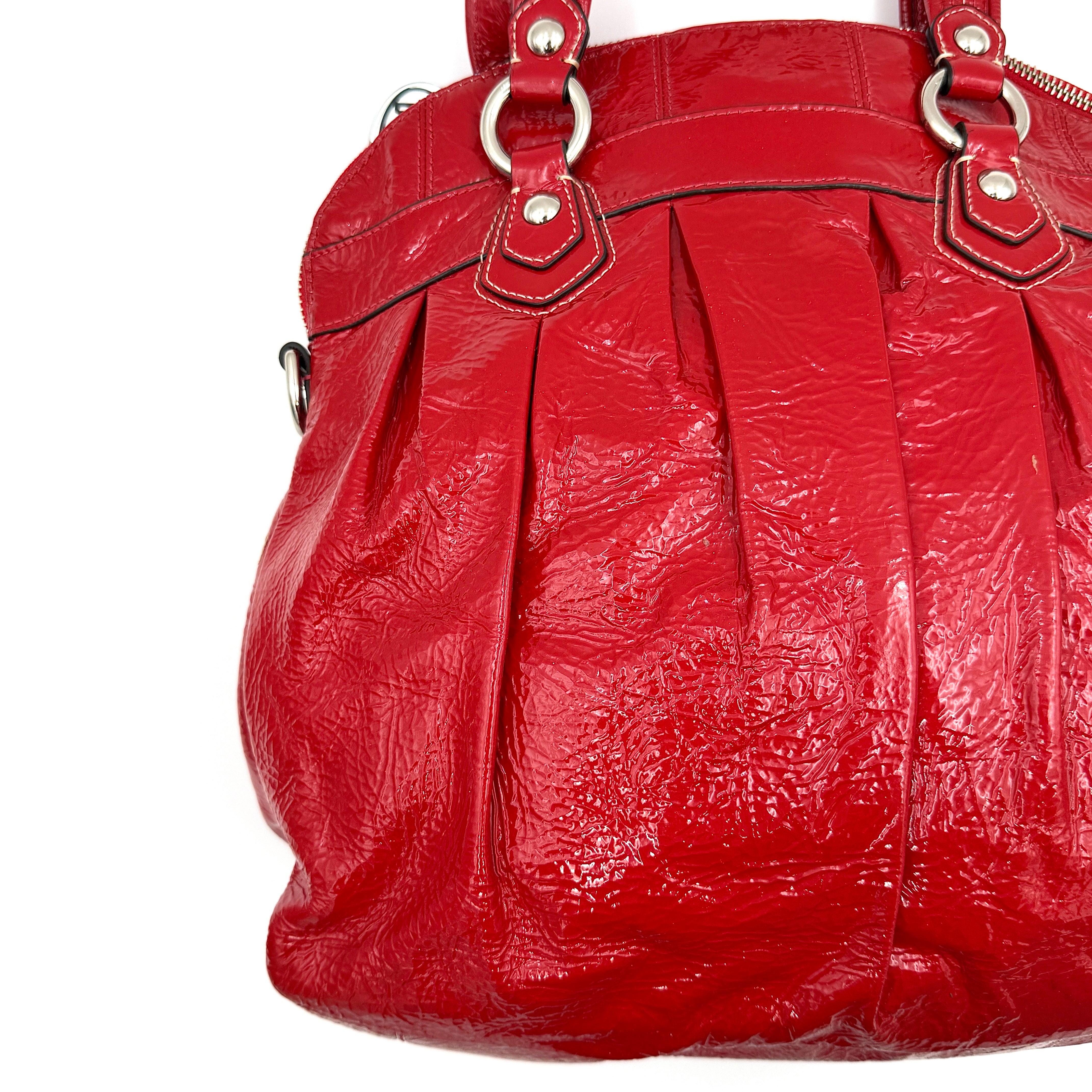 Coach Poppy 2Way shoulder bag in glossy red patent leather with floral appliqué, heart charm, double handles and detachable long strap.