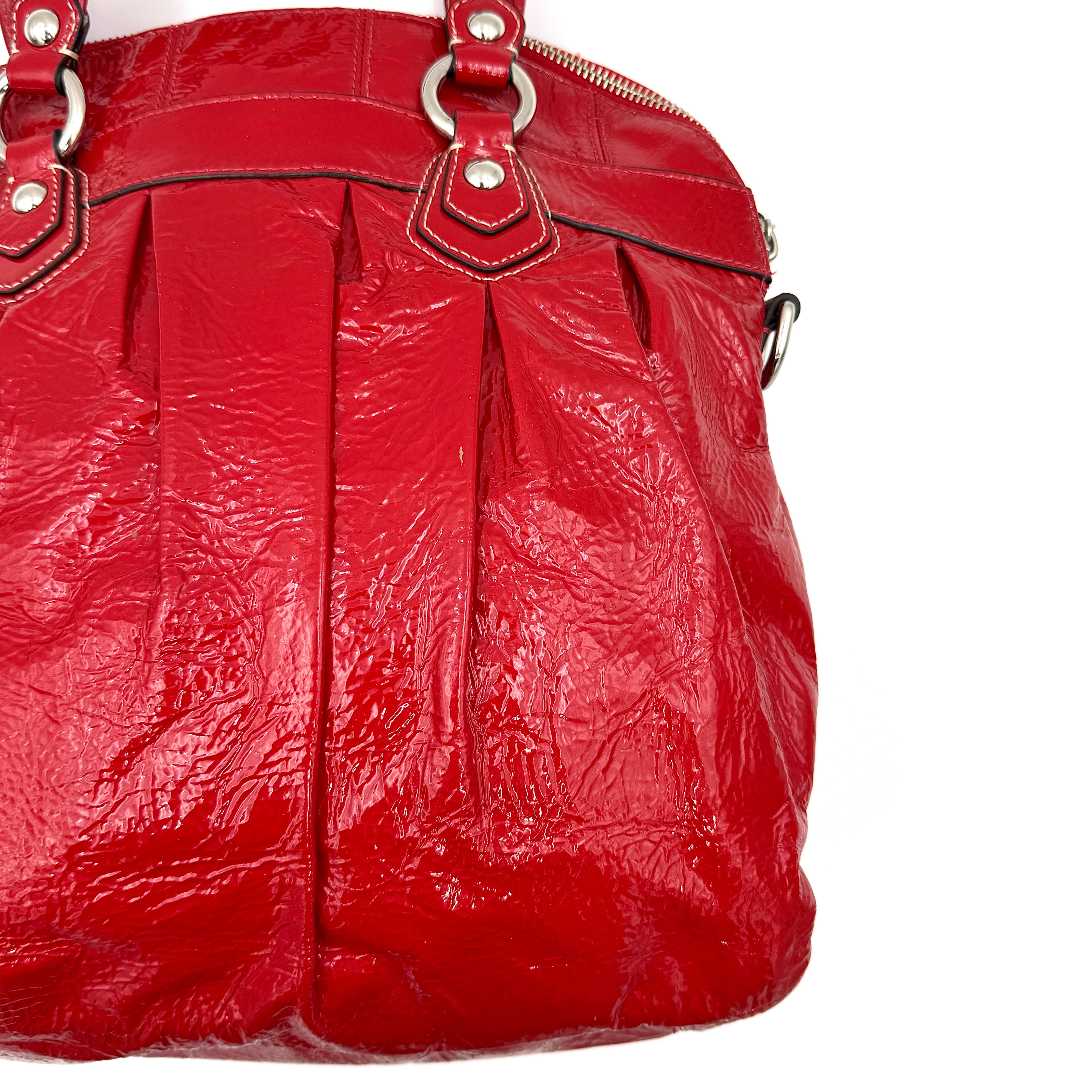 Coach Poppy 2Way shoulder bag in glossy red patent leather with floral appliqué, heart charm, double handles and detachable long strap.