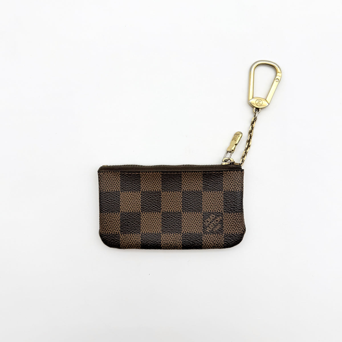 Louis Vuitton Damier Ebene key coin pouch in brown with gold-tone hardware and chain clasp, photographed on a white background.
