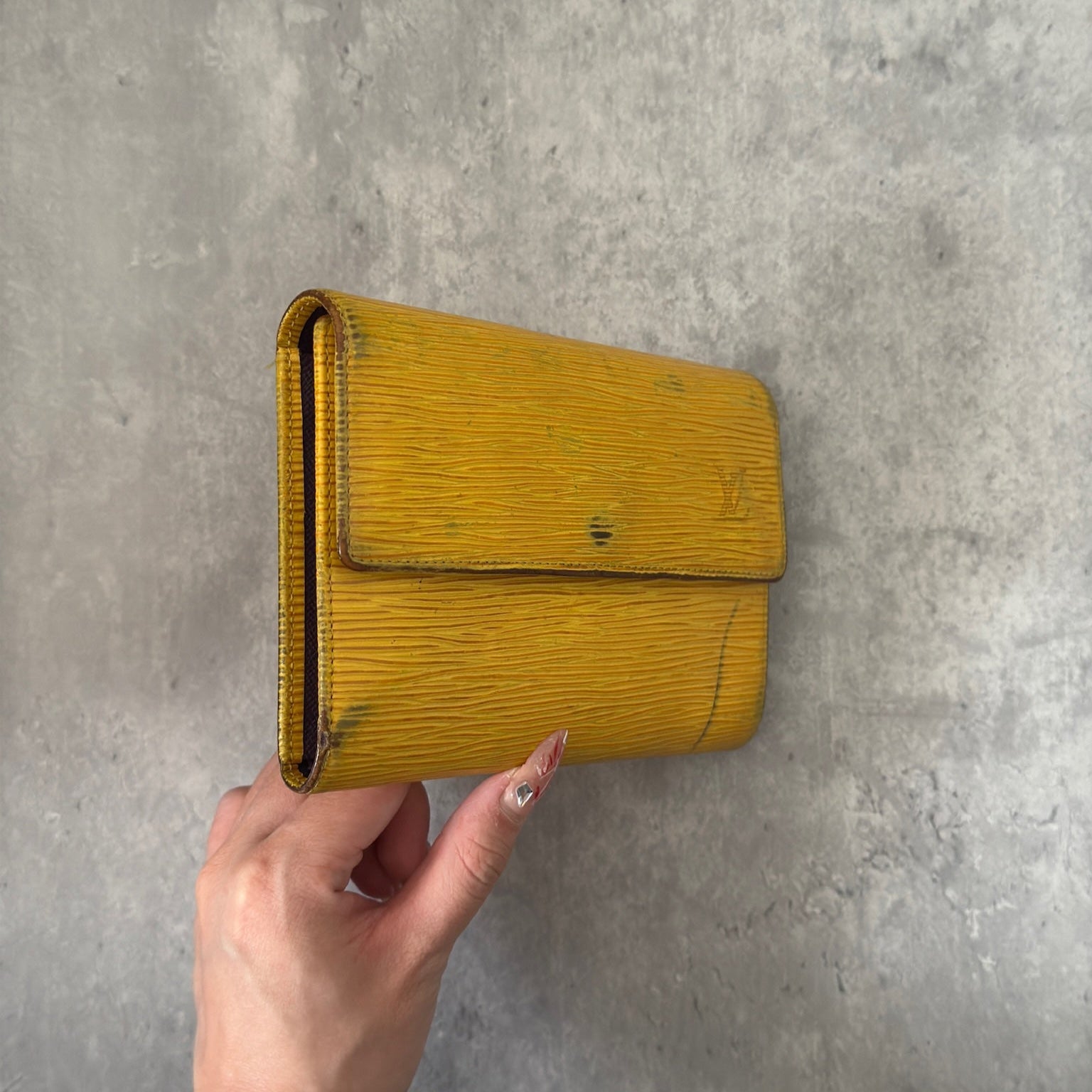 Louis Vuitton Epi leather wallet in yellow with purple leather interior, showcasing multiple card slots and a spacious bill compartment, a blend of functionality and luxury.