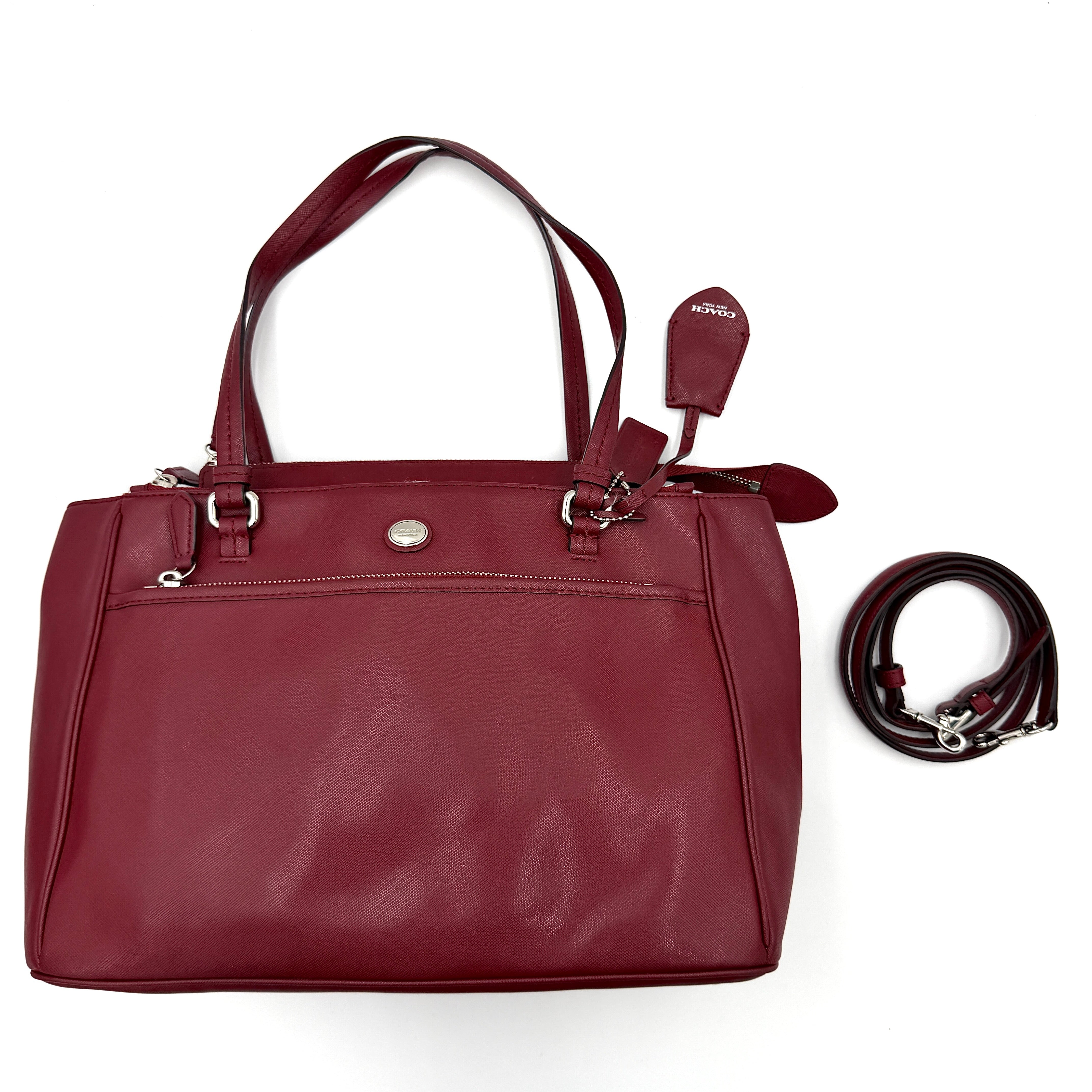 Coach 2Way Peyton Carryall Shoulder Bag in maroon leather with silver hardware, top handles, and detachable strap styled beside the bag.
