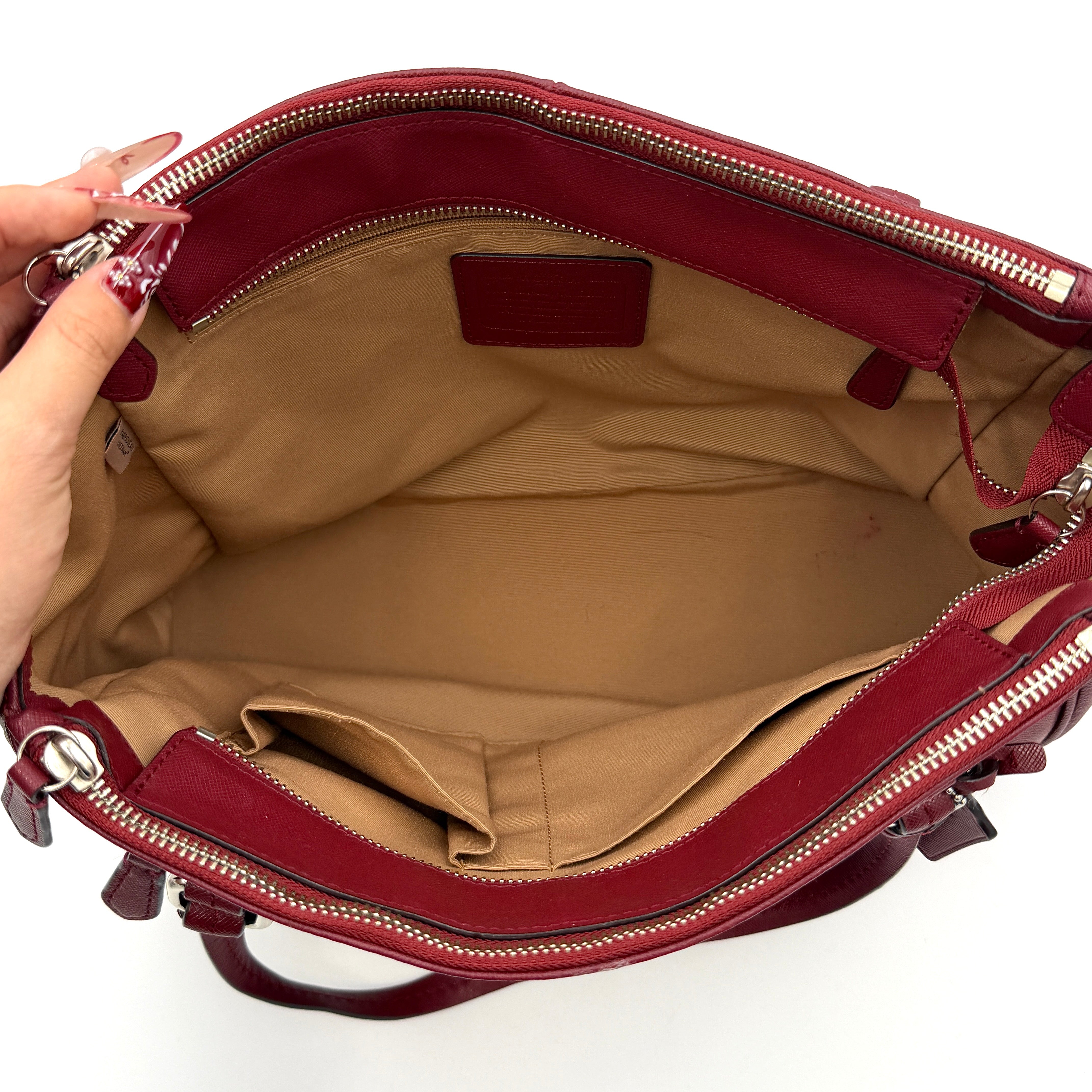 Coach 2Way Peyton Carryall Shoulder Bag in maroon leather with silver hardware, top handles, and detachable strap styled beside the bag.