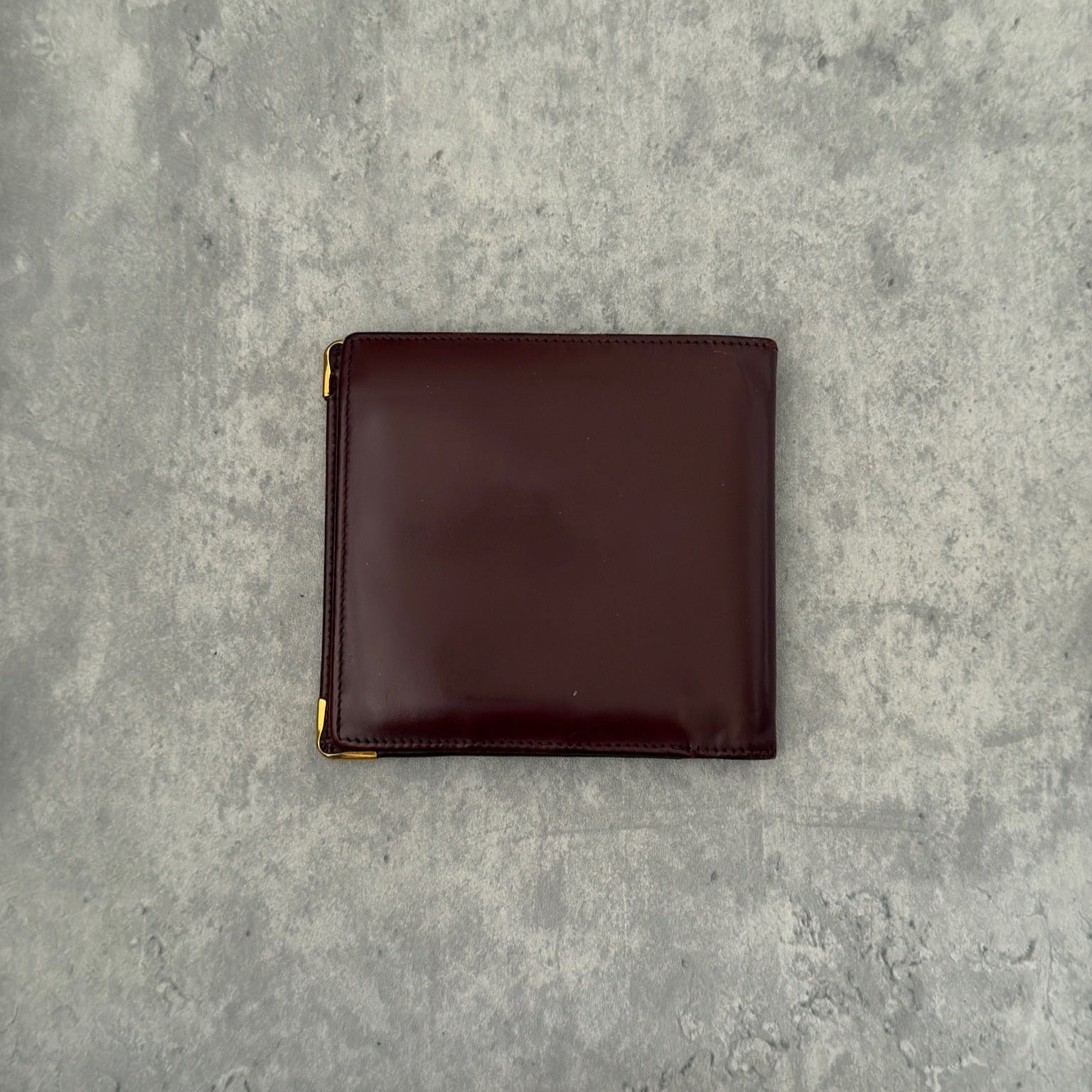 Cartier burgundy patent leather cardholder with multiple card slots, showcasing a luxurious and glossy finish, ideal for elegant organization.