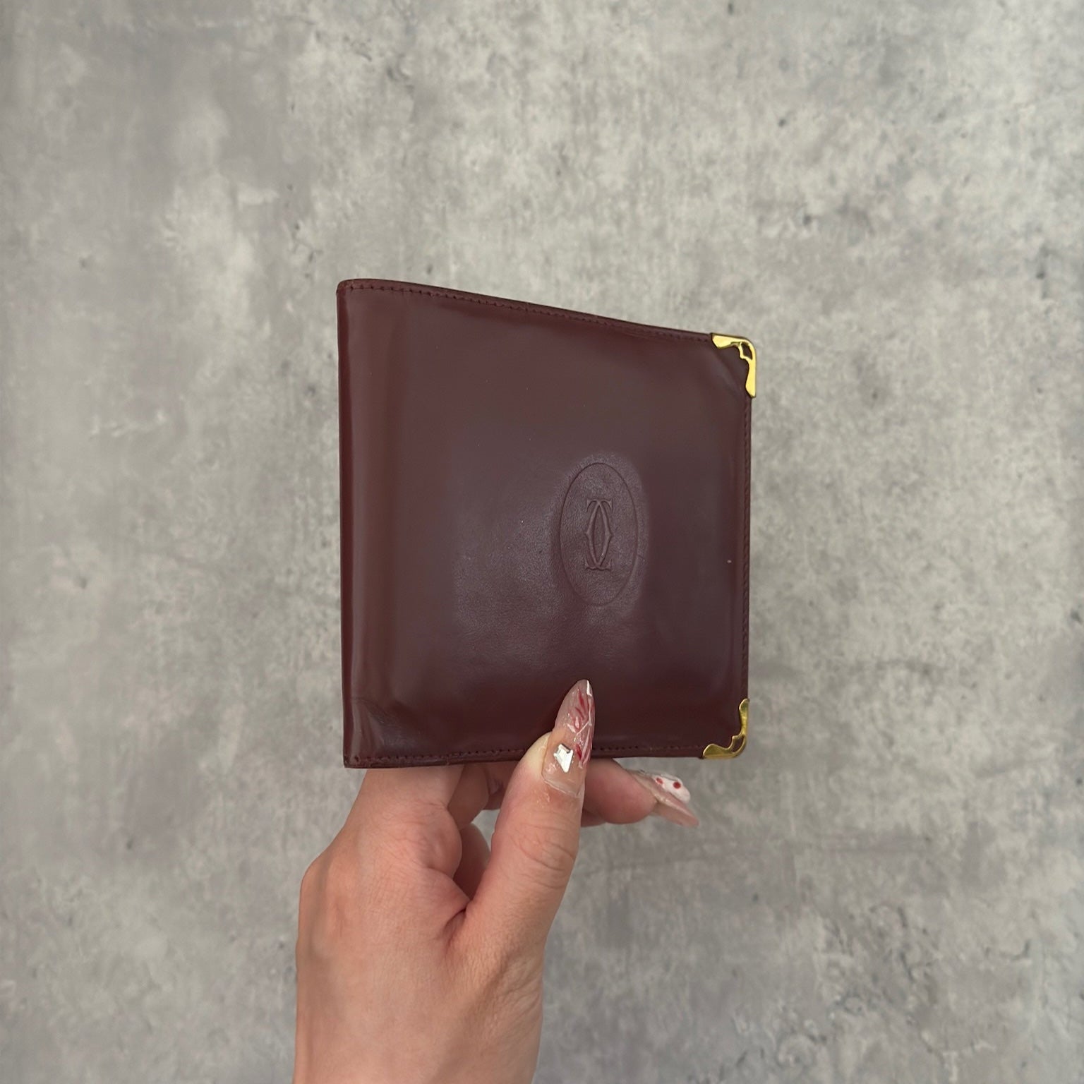 Cartier burgundy patent leather cardholder with multiple card slots, showcasing a luxurious and glossy finish, ideal for elegant organization.