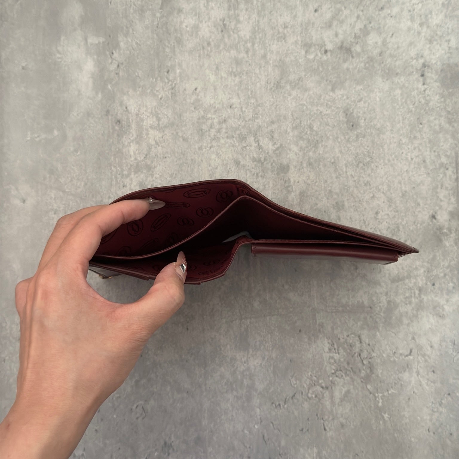 Cartier burgundy patent leather cardholder with multiple card slots, showcasing a luxurious and glossy finish, ideal for elegant organization.