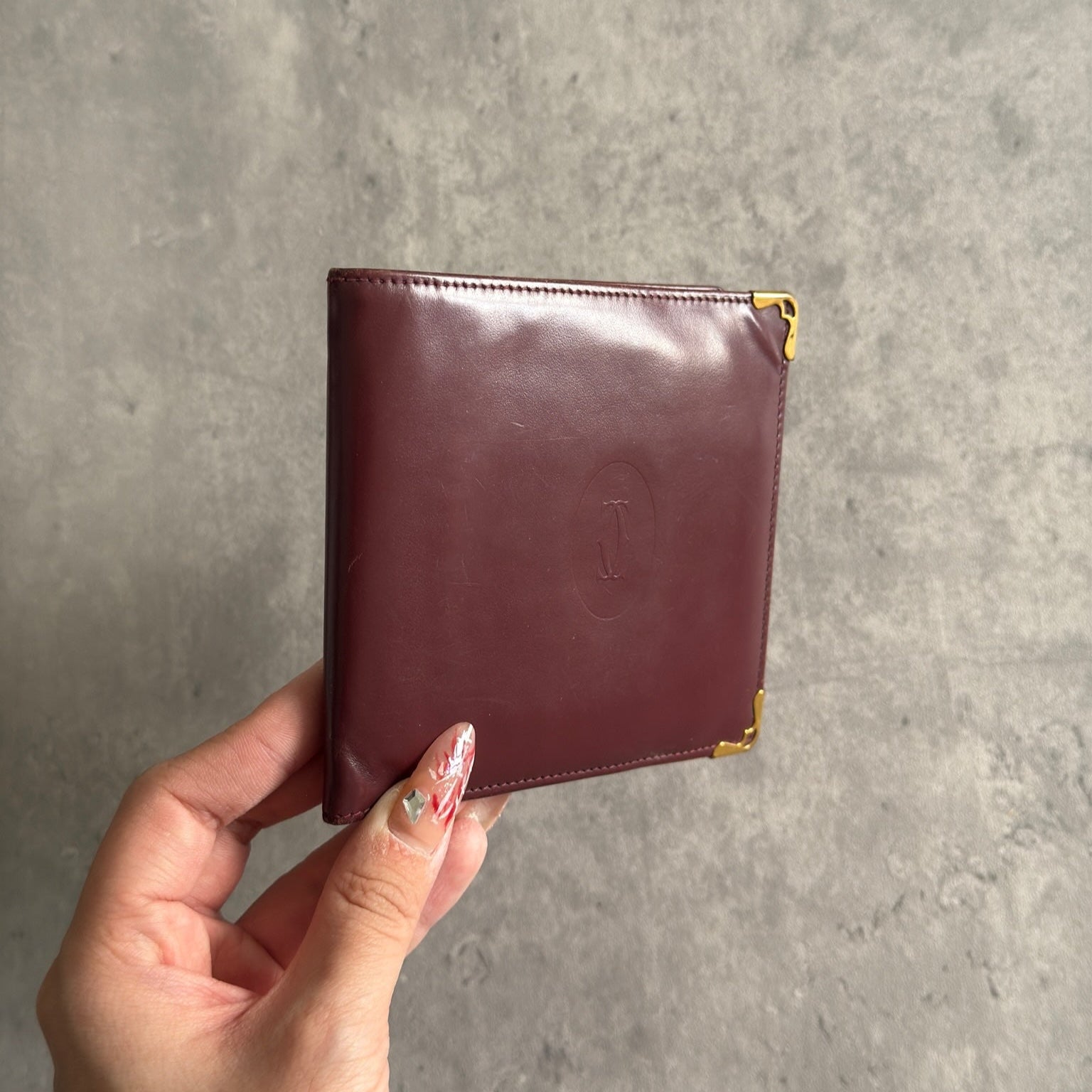 Cartier burgundy patent leather cardholder with multiple card slots, showcasing a luxurious and glossy finish, ideal for elegant organization.
