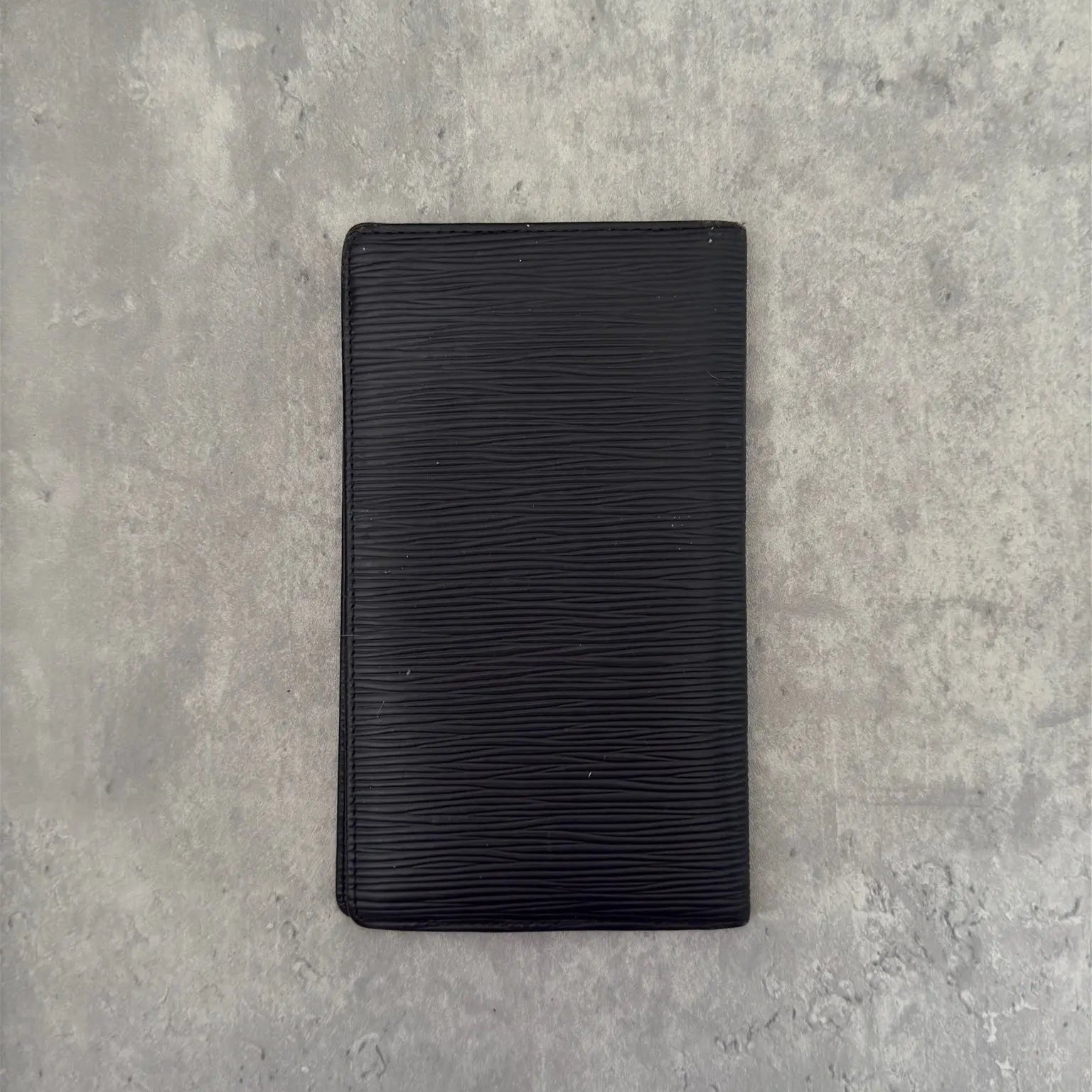 Louis Vuitton Porte Yen Cartes Credit Long Wallet in black Epi leather, featuring multiple card slots, a bill compartment, and LV embossed logo, epitomizing luxury and functionality.