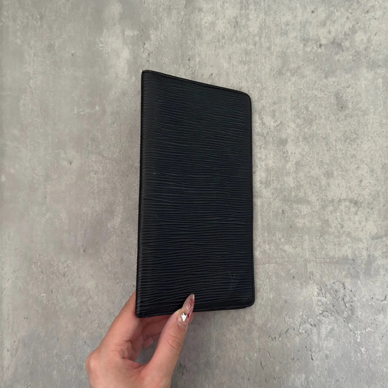 Louis Vuitton Porte Yen Cartes Credit Long Wallet in black Epi leather, featuring multiple card slots, a bill compartment, and LV embossed logo, epitomizing luxury and functionality.