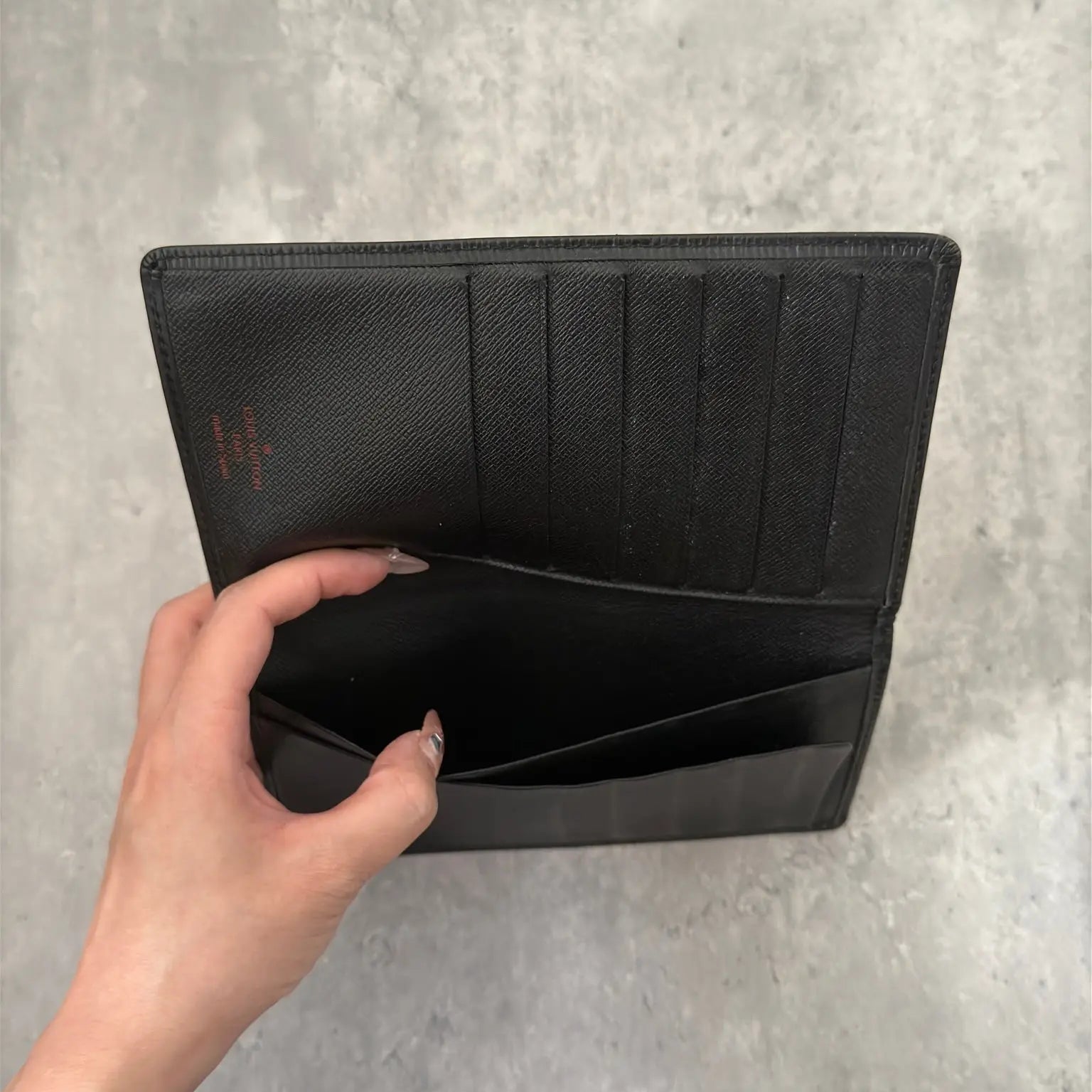 Louis Vuitton Porte Yen Cartes Credit Long Wallet in black Epi leather, featuring multiple card slots, a bill compartment, and LV embossed logo, epitomizing luxury and functionality.