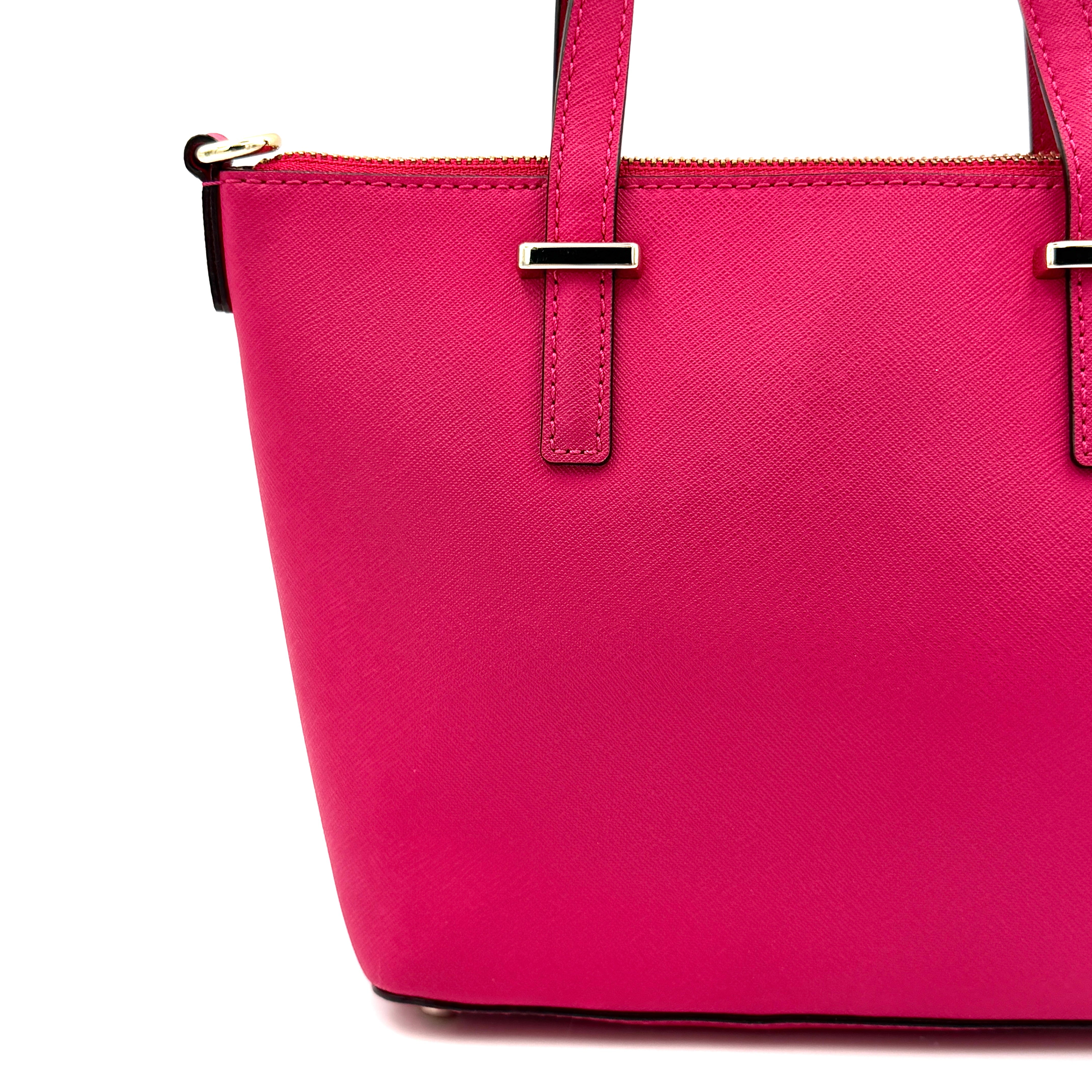 Kate Spade Cedar Street handbag in bold fuchsia pink Saffiano leather, shown with top handles and detachable strap alongside.