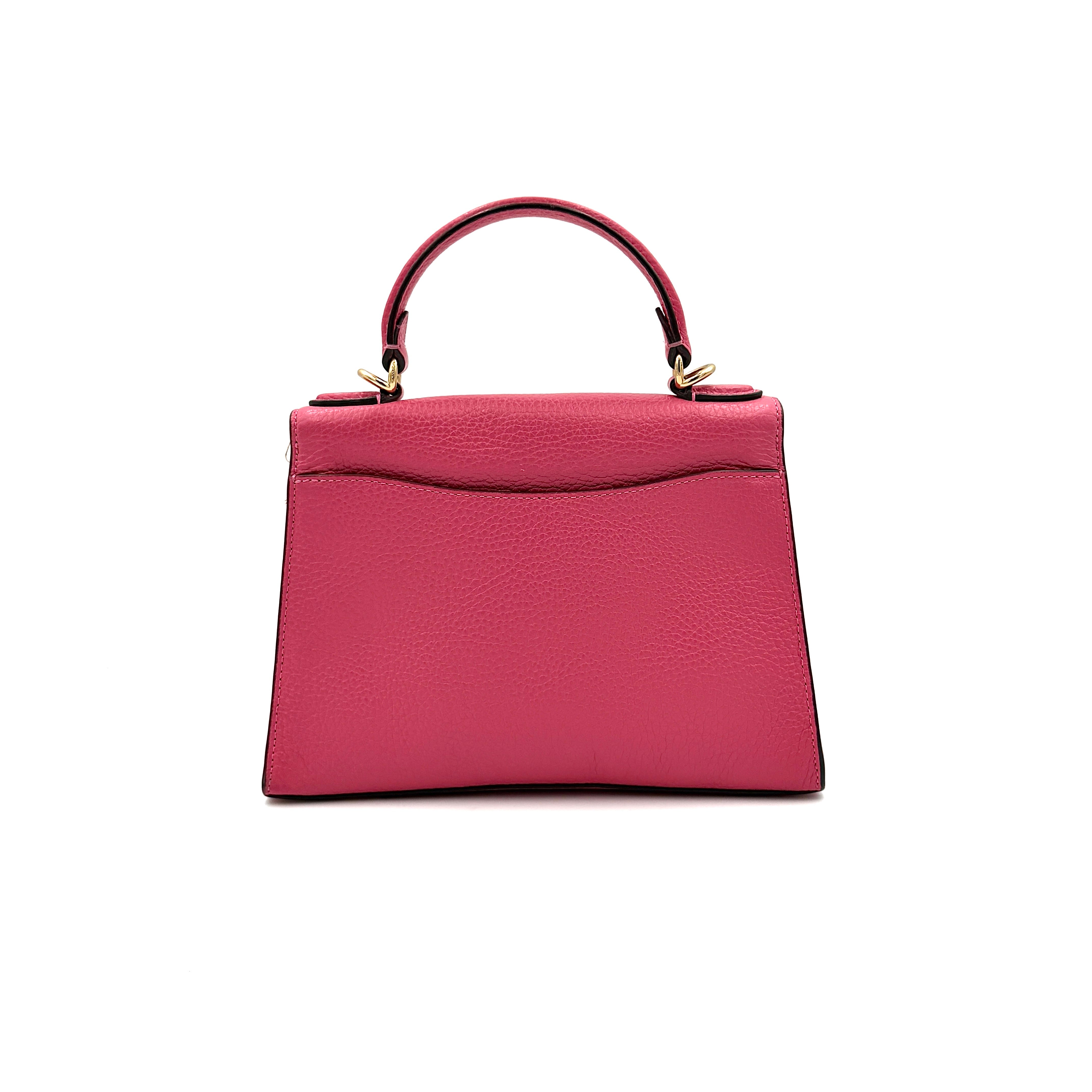 Coach Pepper Satchel in bold pink pebbled leather, featuring a structured silhouette and gold logo push-lock hardware.
