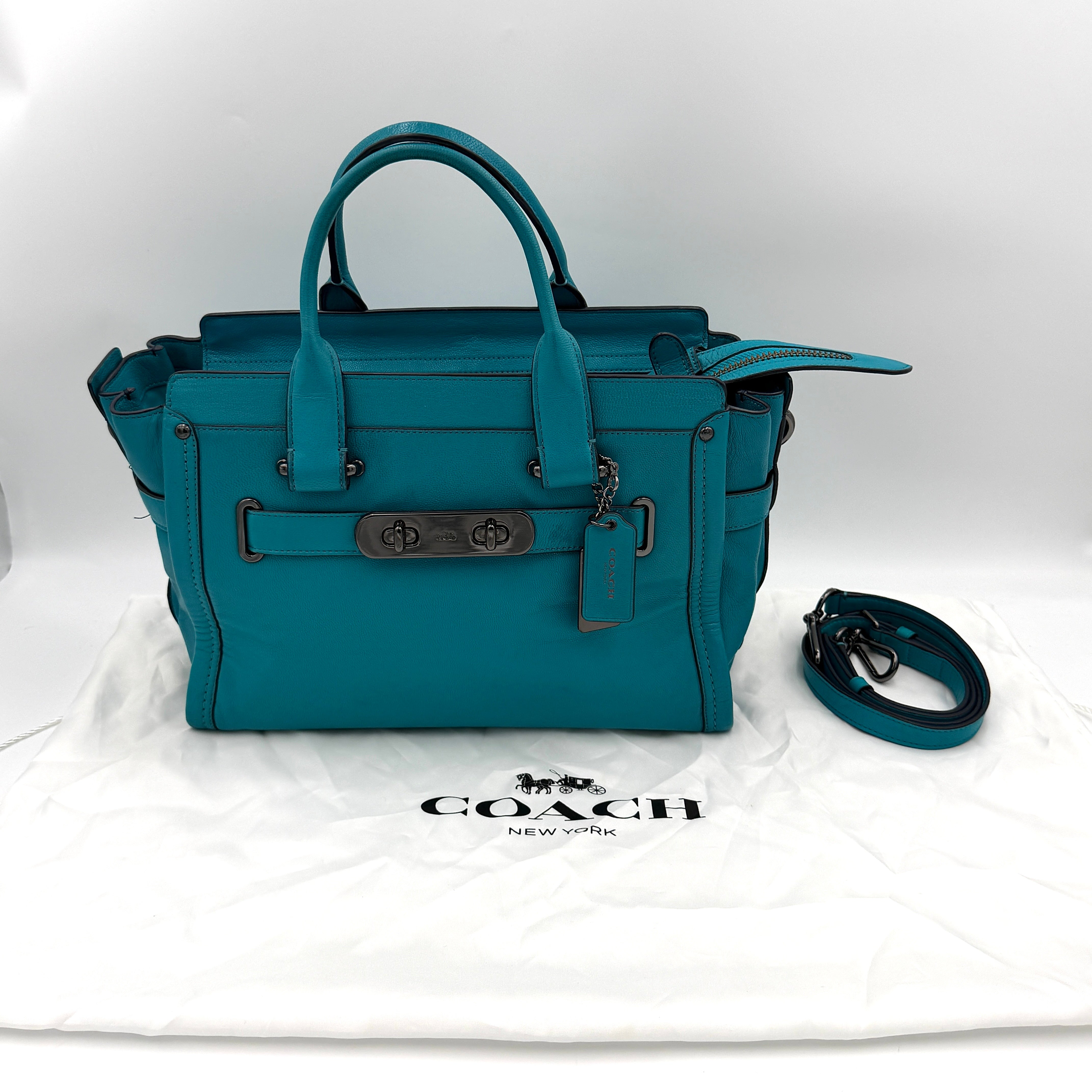 Coach Swagger 27 Carryall in vivid turquoise leather with double top handles, gunmetal hardware, and detachable strap.