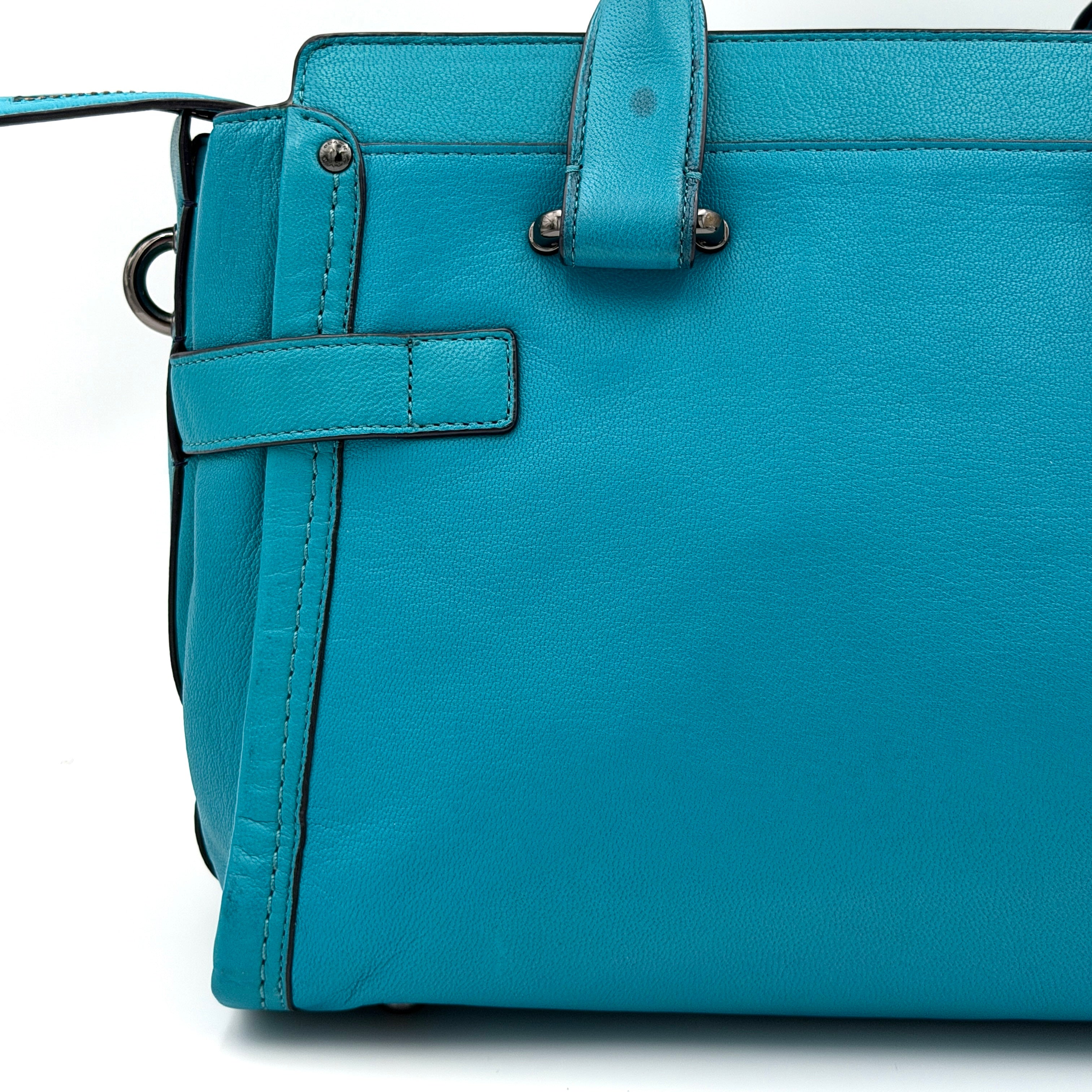 Coach Swagger 27 Carryall in vivid turquoise leather with double top handles, gunmetal hardware, and detachable strap.
