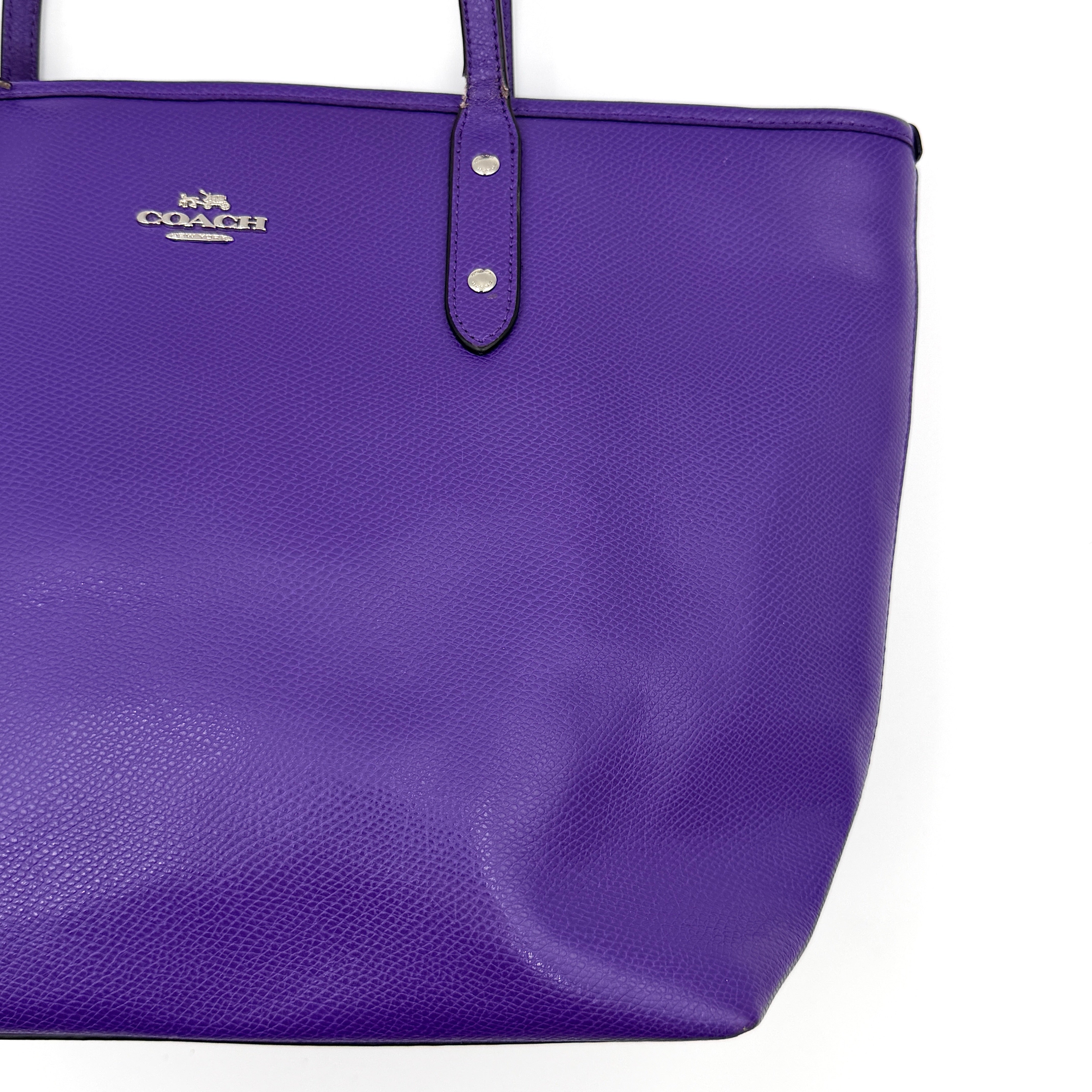 Coach City Zip Tote Bag in vibrant purple grained leather with dual shoulder straps and silver-tone hardware.