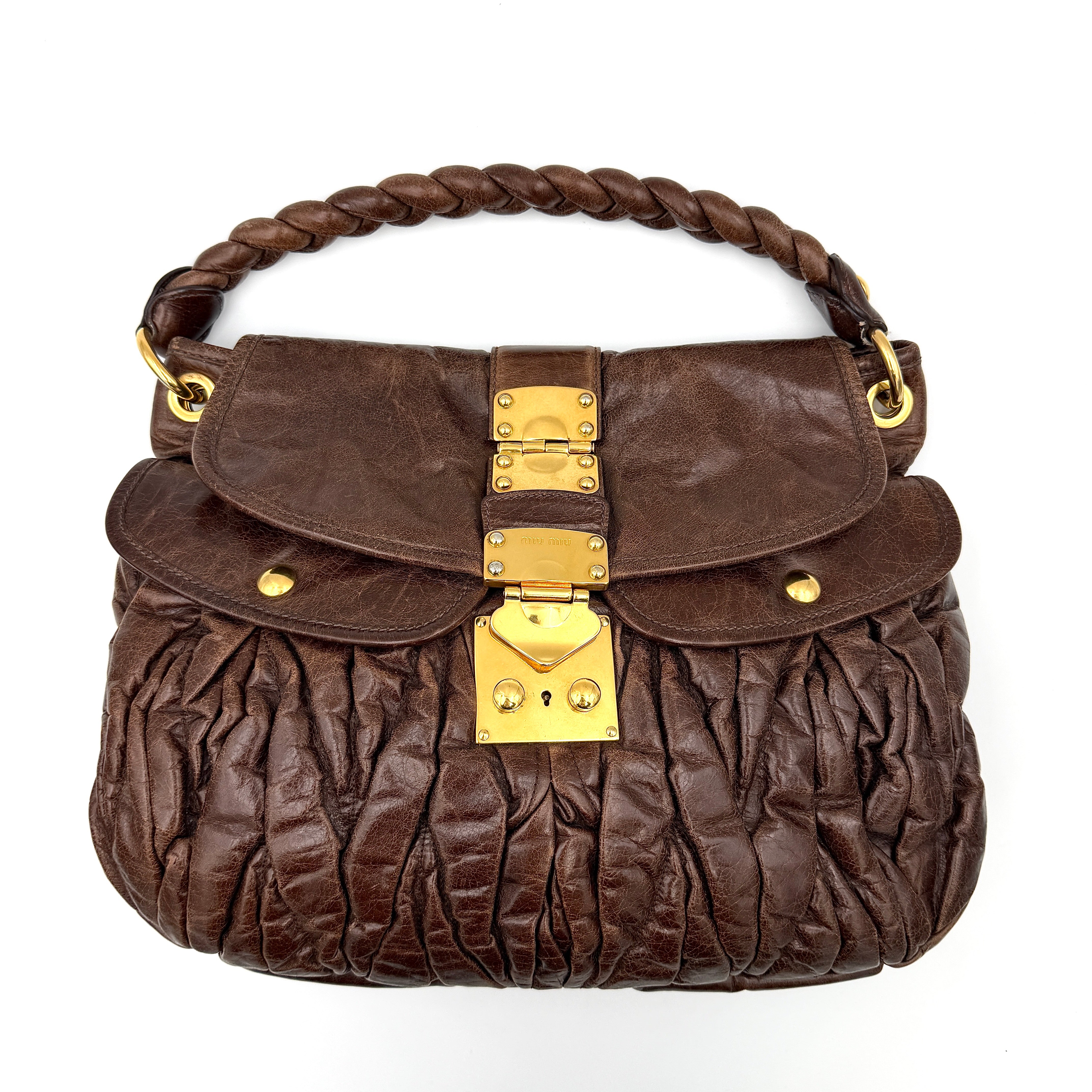 Miu Miu Coffer Hobo bag in deep brown matelassé leather with braided handle, gold hardware, and detachable strap.