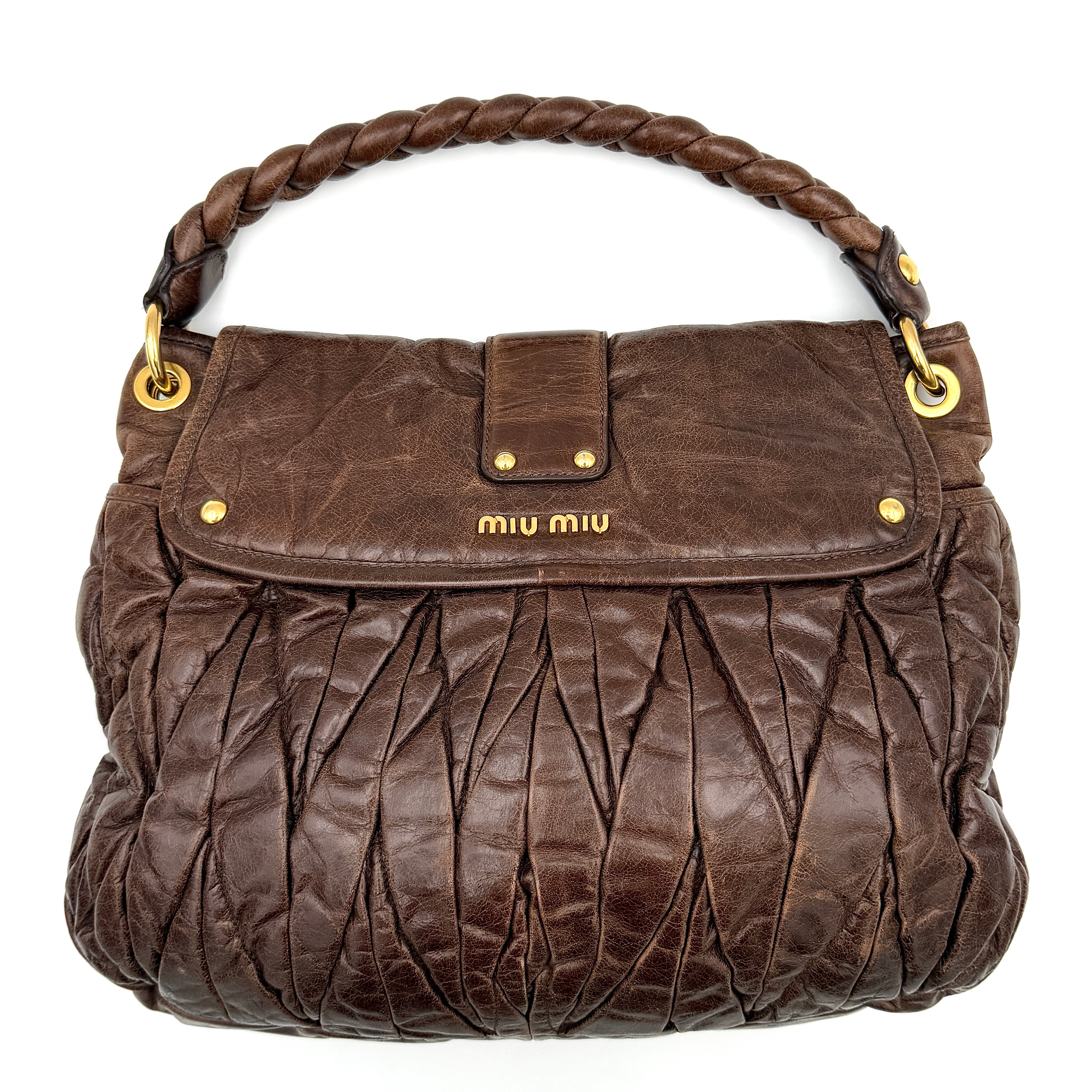 Miu Miu Coffer Hobo bag in deep brown matelassé leather with braided handle, gold hardware, and detachable strap.