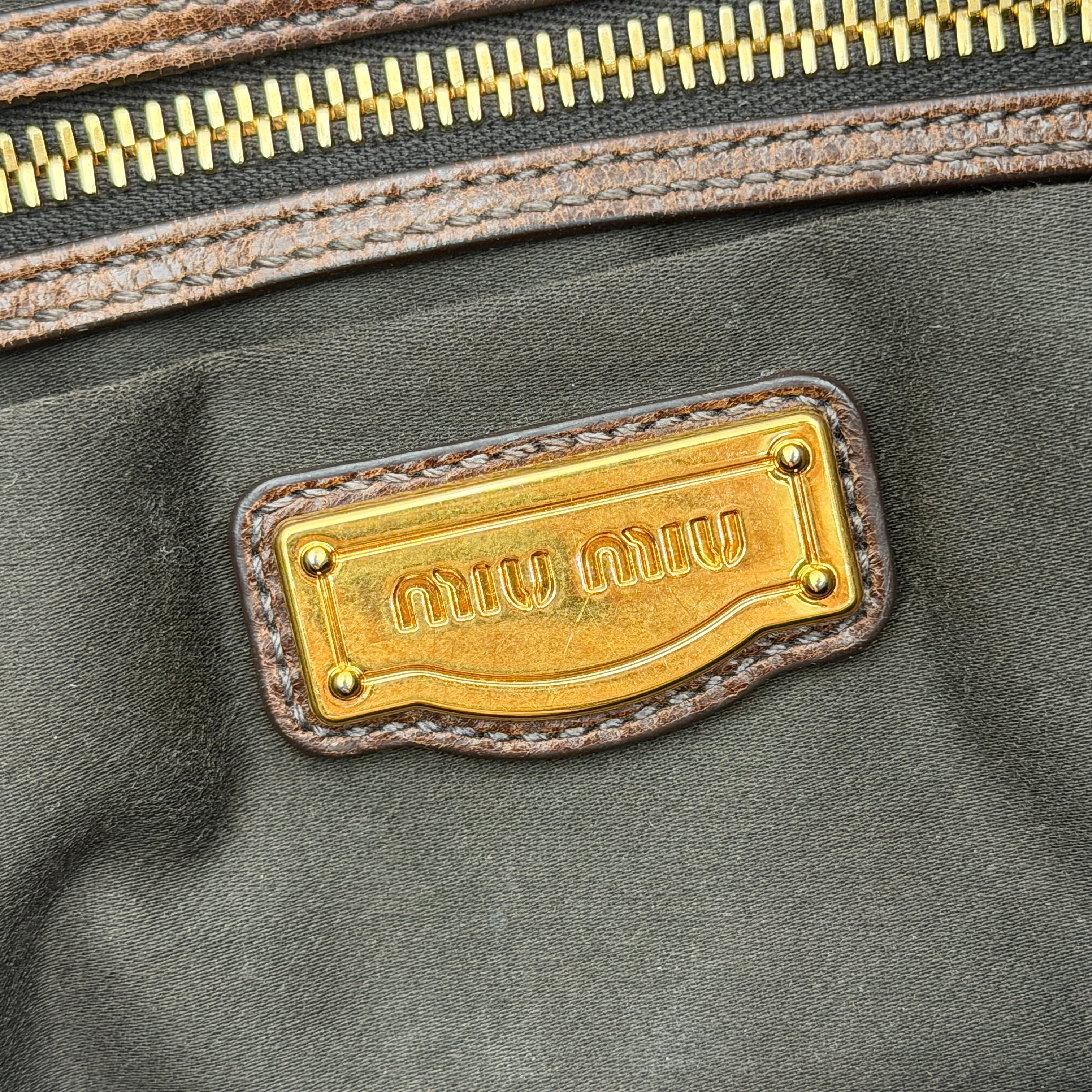 Miu Miu Coffer Hobo bag in deep brown matelassé leather with braided handle, gold hardware, and detachable strap.