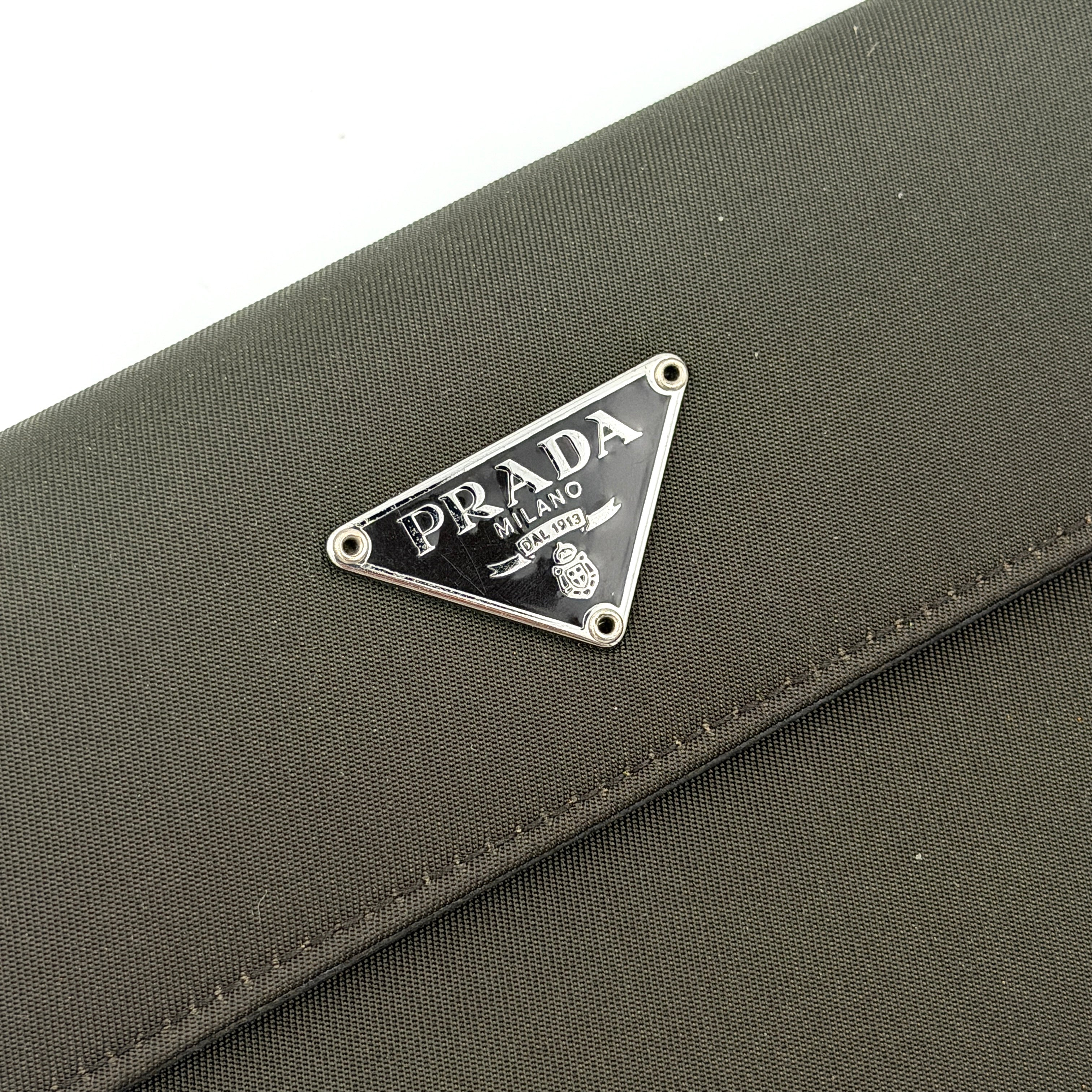 Prada Tessuto Nylon Bifold Wallet in black featuring the iconic enamel triangle logo on the front flap.