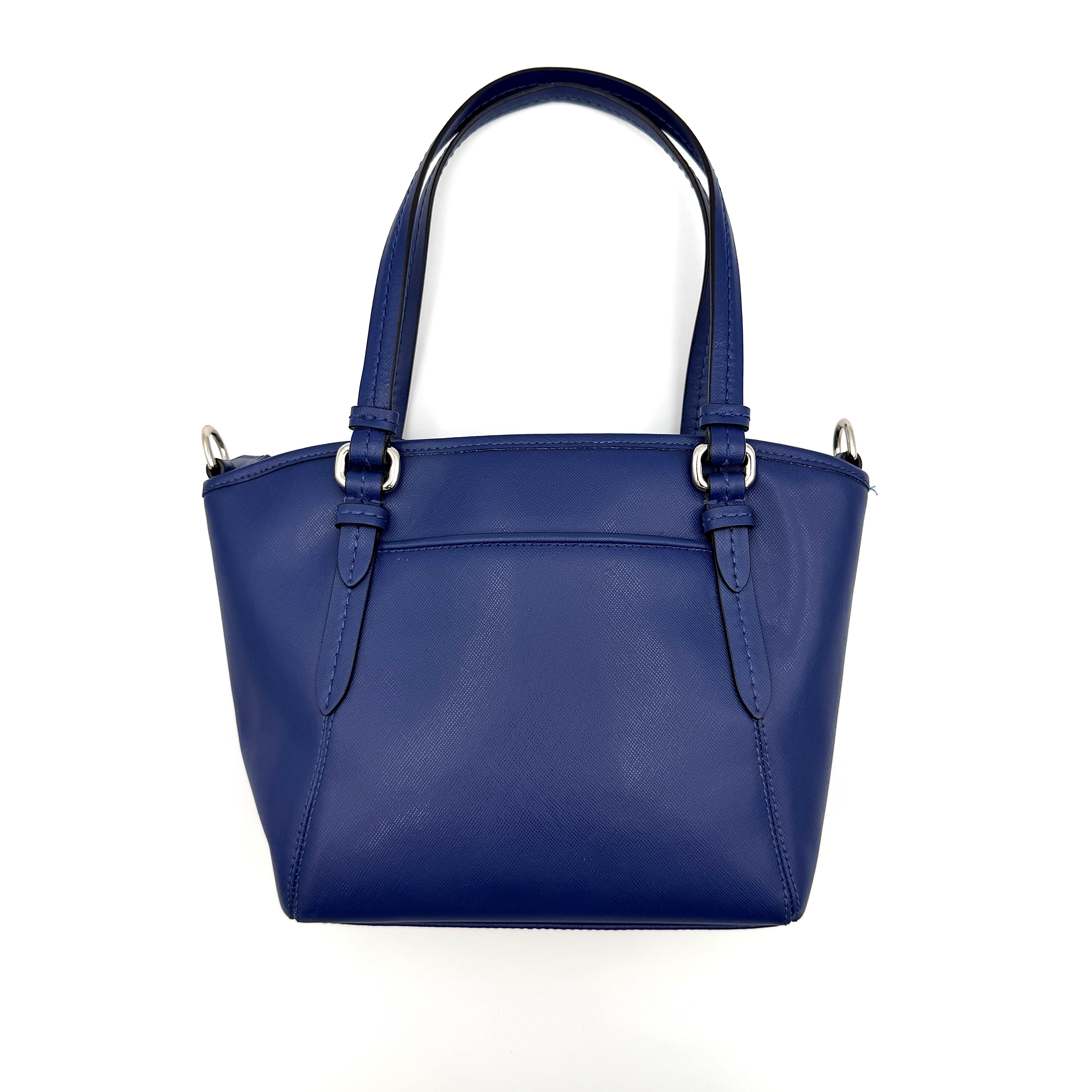 A structured cobalt blue Coach tote bag with silver hardware, dual handles, and an optional crossbody strap, displayed against a clean background.
