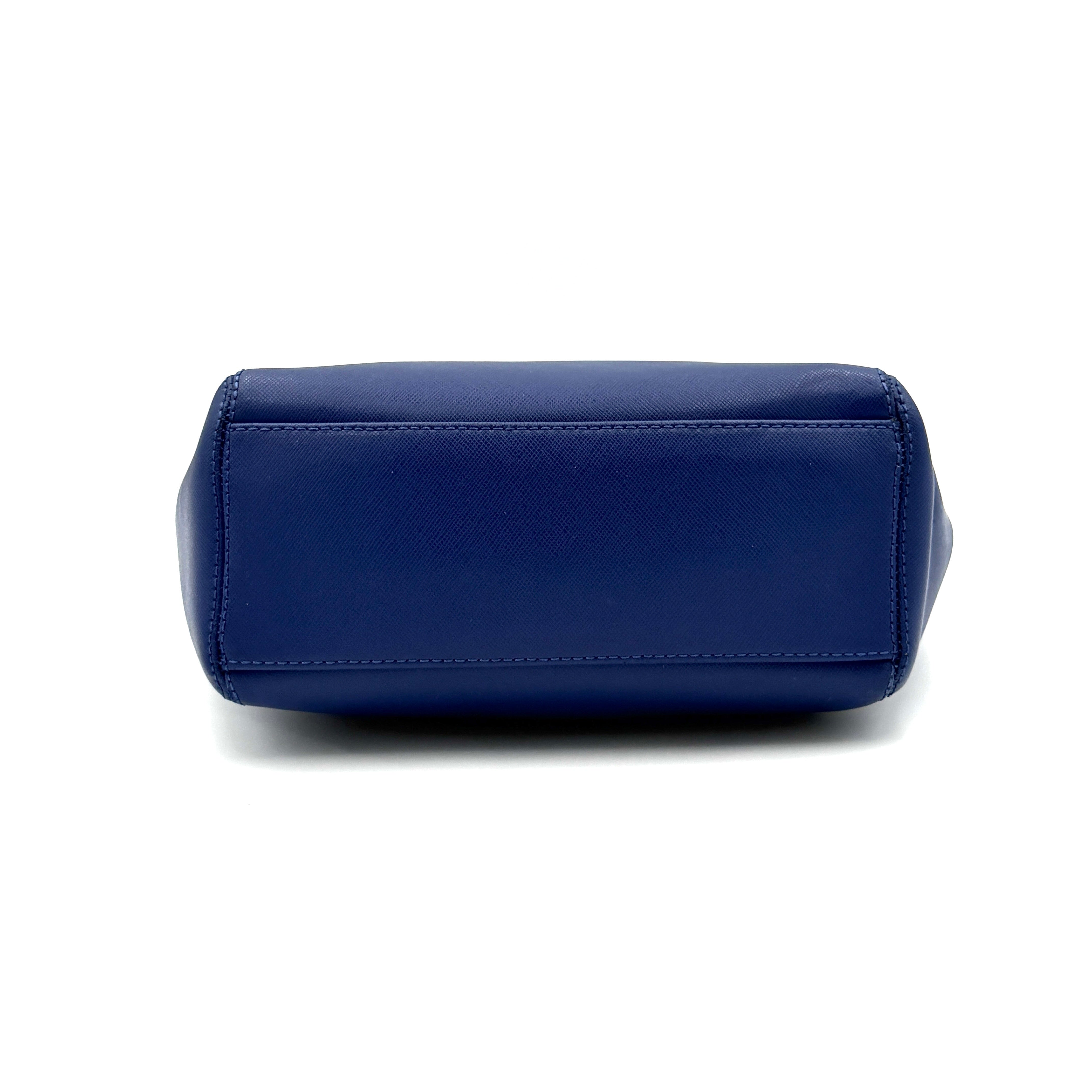 A structured cobalt blue Coach tote bag with silver hardware, dual handles, and an optional crossbody strap, displayed against a clean background.