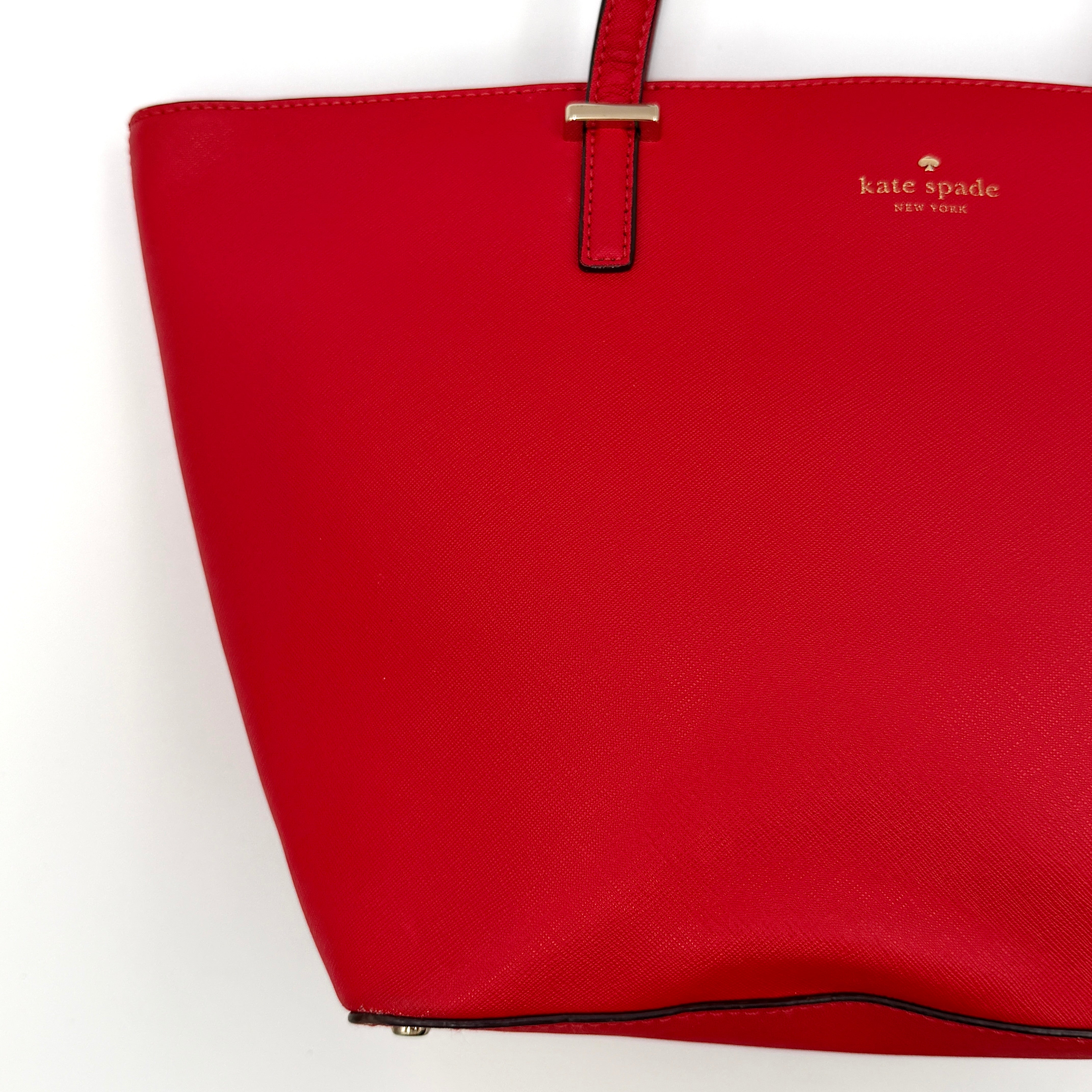A vivid red Kate Spade Cedar Street Harmony Tote Bag with structured handles and gold-tone logo, shown against a white background.