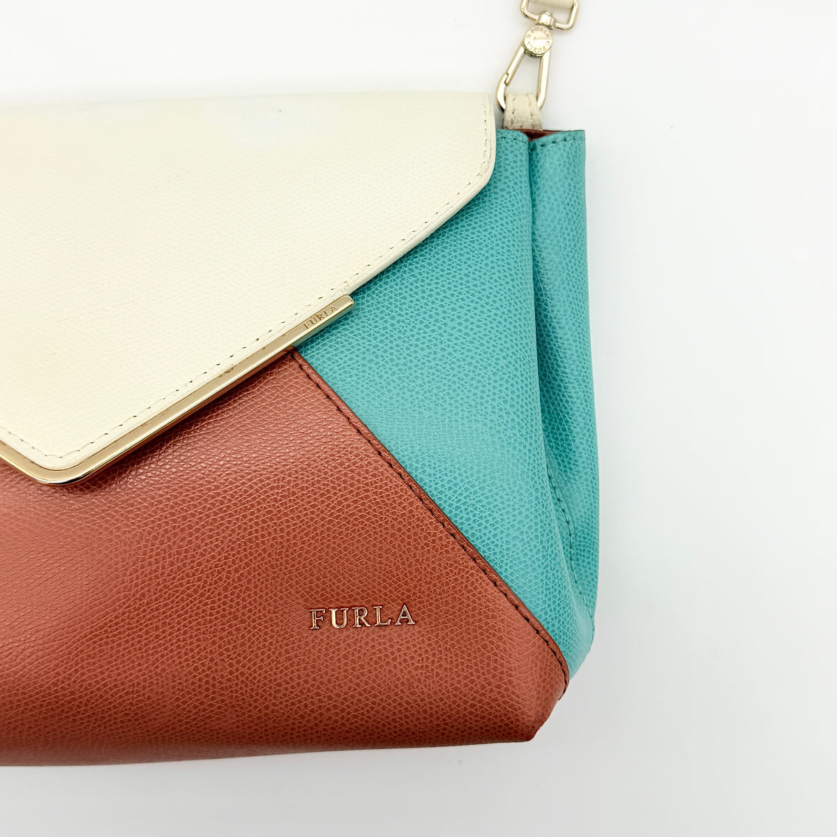 Furla Kelis crossbody bag in brown, blue, and cream leather with envelope flap and gold-tone hardware, displayed on a Furla dust bag.