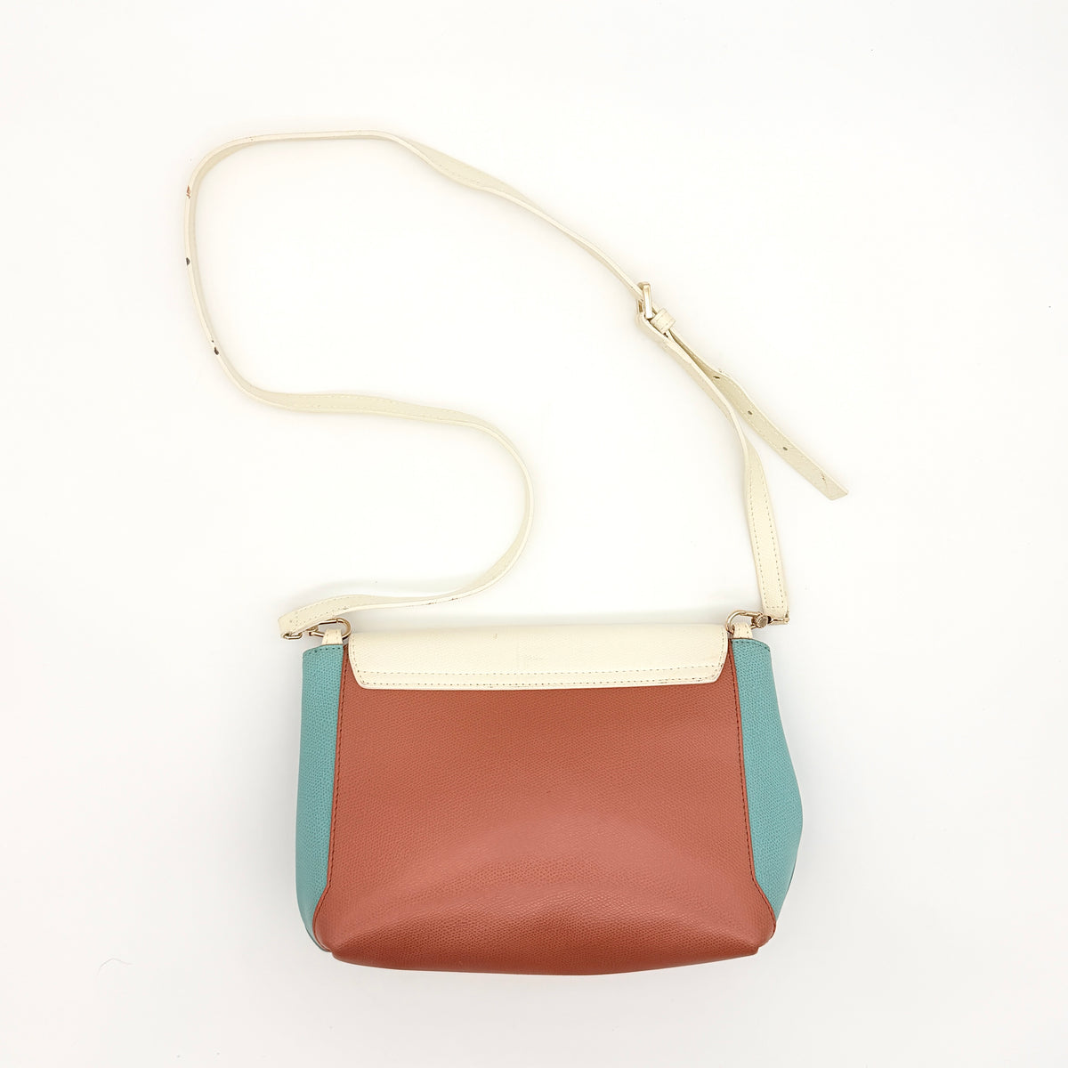 Furla Kelis crossbody bag in brown, blue, and cream leather with envelope flap and gold-tone hardware, displayed on a Furla dust bag.
