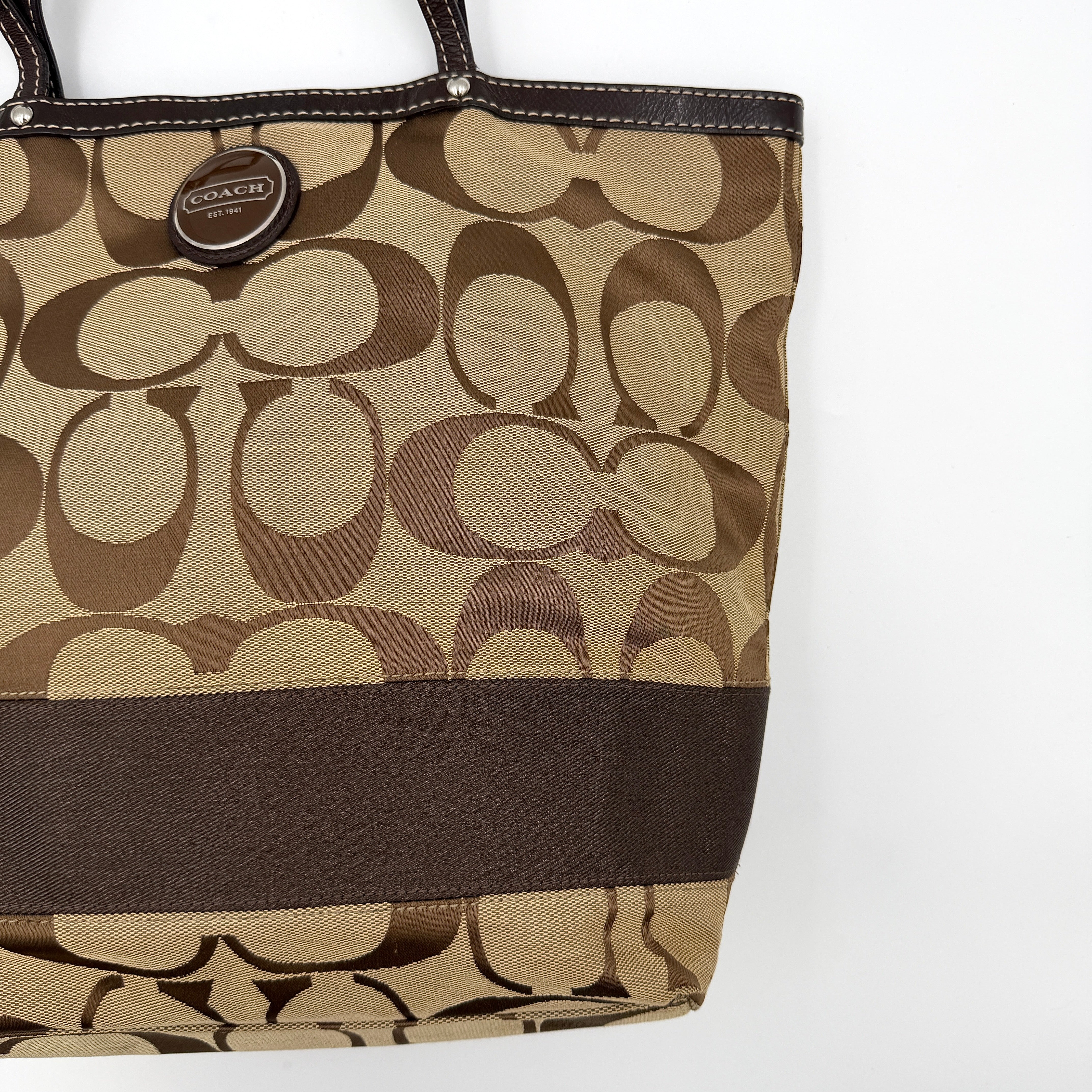 Coach Signature Stripe Tote Bag in brown and beige monogram canvas with chocolate stripe and leather handles, photographed upright.