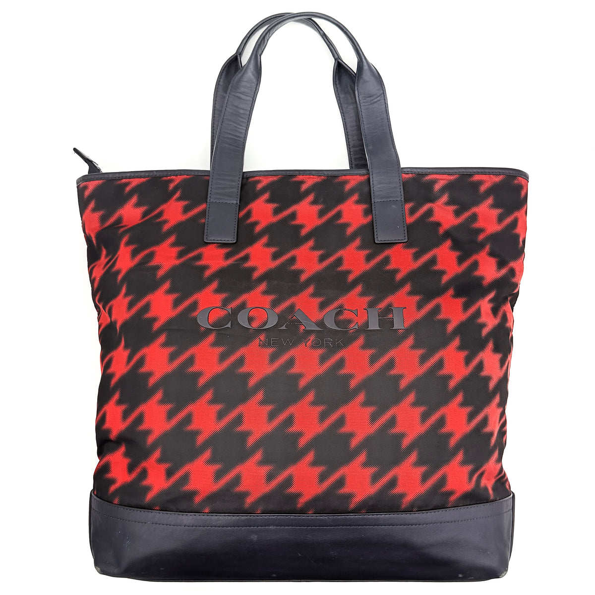 Coach Mercer Print Houndstooth Tote Bag in red and black with leather trim and handles, photographed upright against a white background.