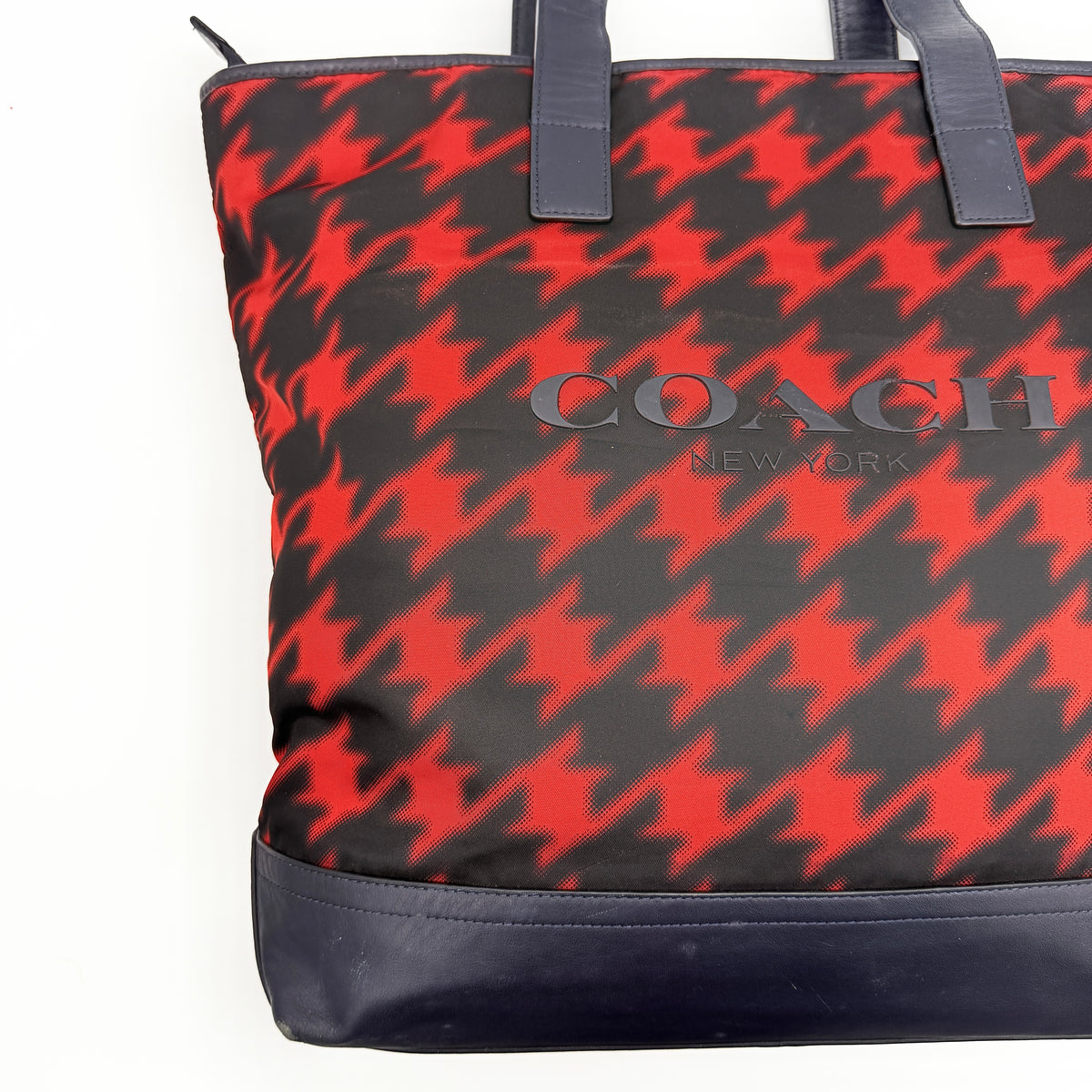 Coach Mercer Print Houndstooth Tote Bag in red and black with leather trim and handles, photographed upright against a white background.