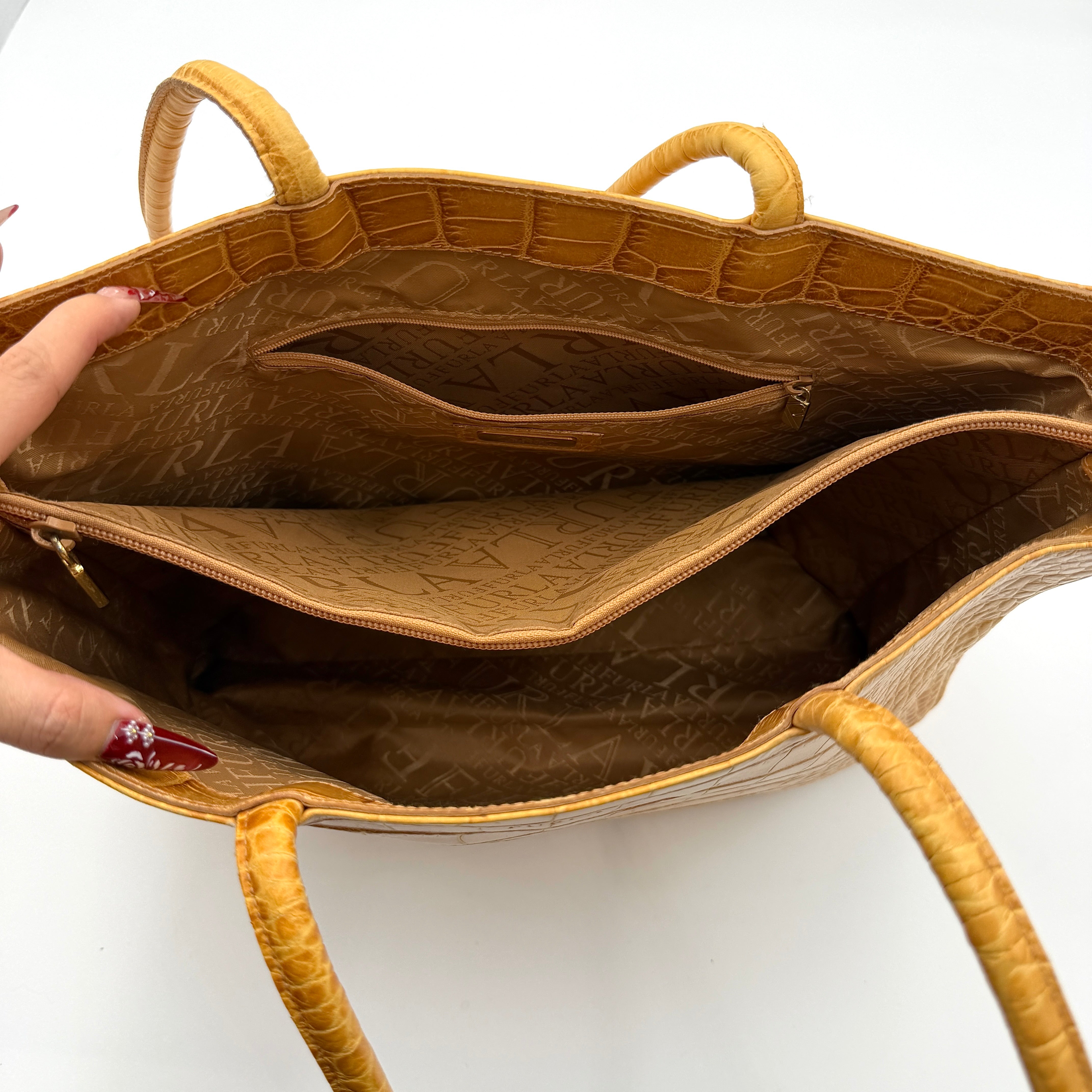 Furla yellow croc-embossed leather tote bag with double handles and matte gold logo charm, presented against a white background.