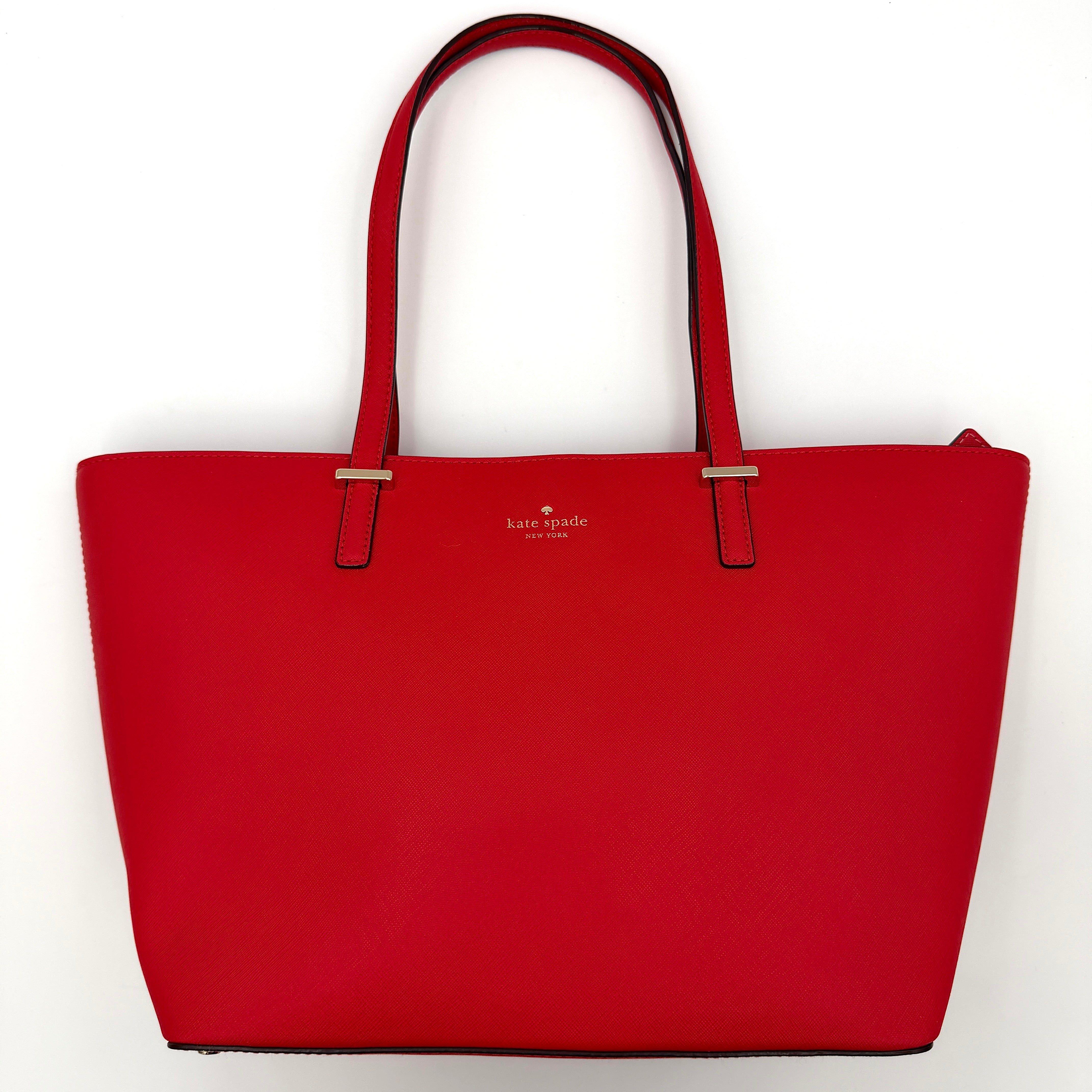 Kate Spade Cedar Street Harmony Tote bag in bold red saffiano leather, featuring dual top handles and gold-tone details.