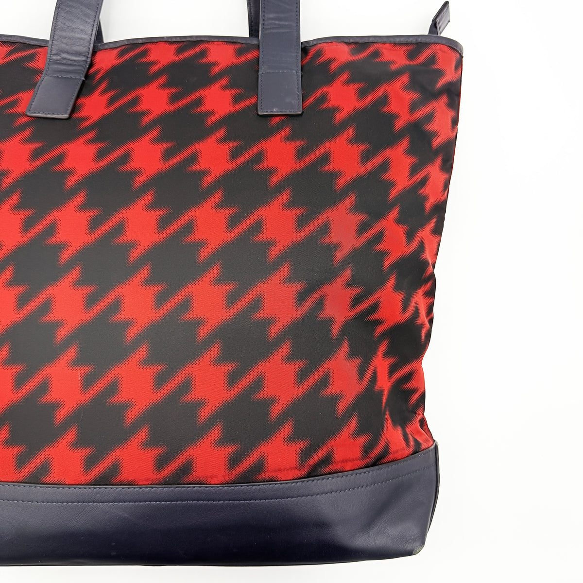 Coach Mercer Print Houndstooth Tote Bag in red and black with leather trim and handles, photographed upright against a white background.