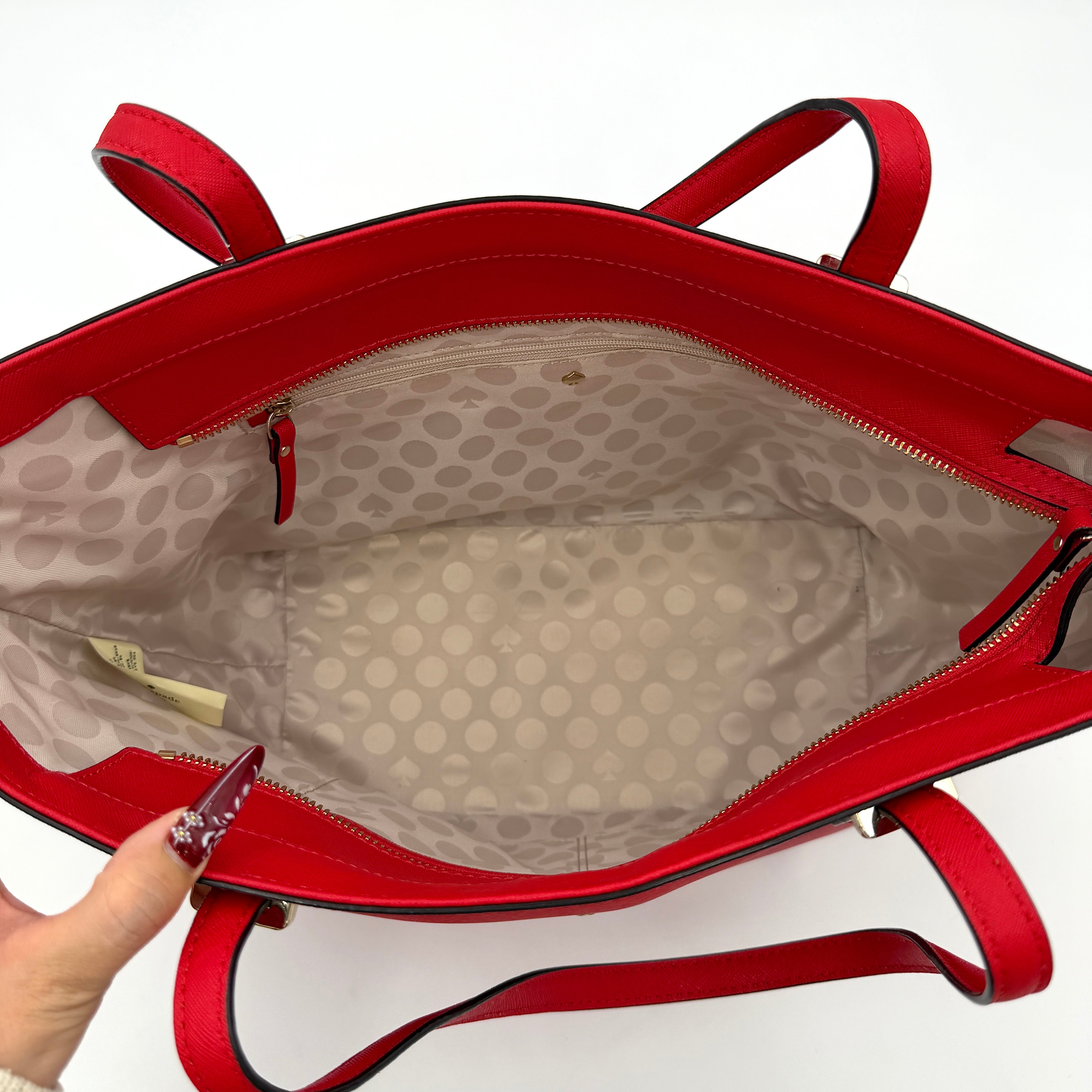 Kate Spade Cedar Street Harmony Tote bag in bold red saffiano leather, featuring dual top handles and gold-tone details.