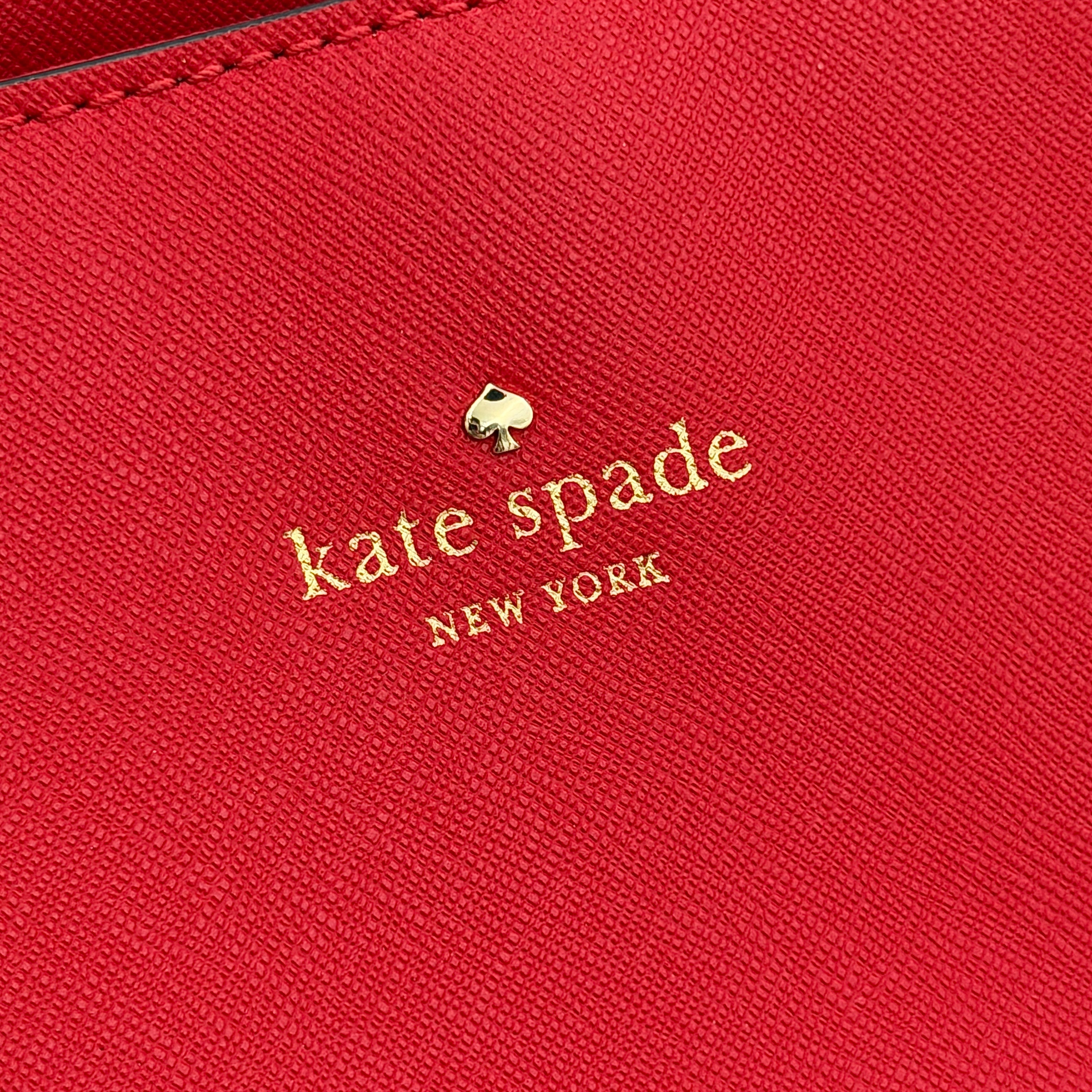Kate Spade Cedar Street Harmony Tote bag in bold red saffiano leather, featuring dual top handles and gold-tone details.