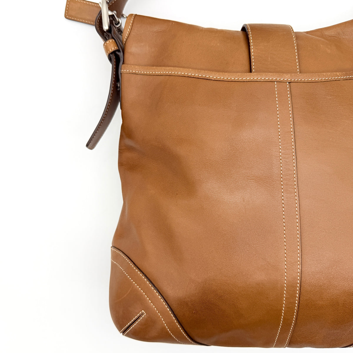Coach Soho Buckle Flap Crossbody Bag in brown leather with buckle flap and adjustable strap, displayed on white background.