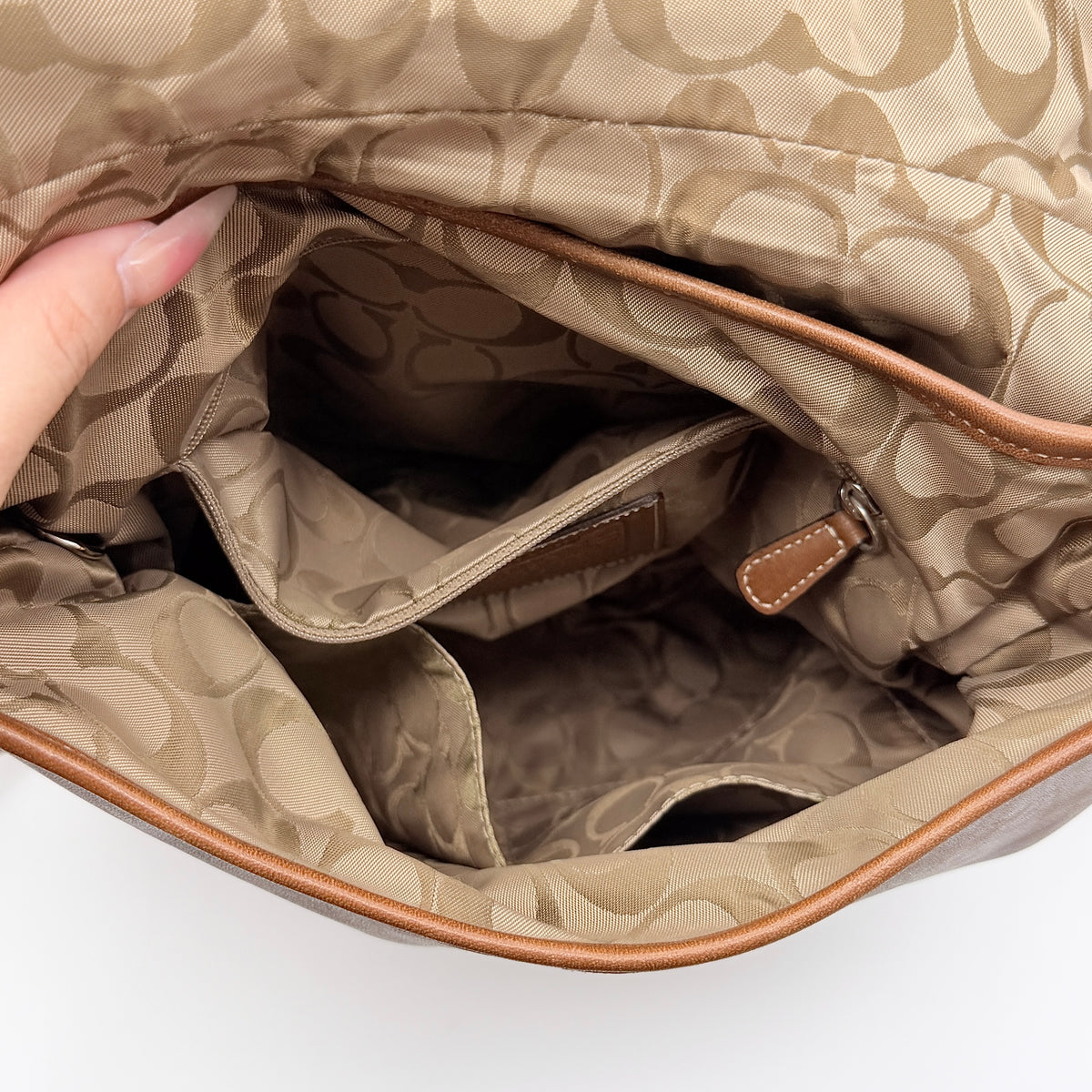 Coach Soho Buckle Flap Crossbody Bag in brown leather with buckle flap and adjustable strap, displayed on white background.