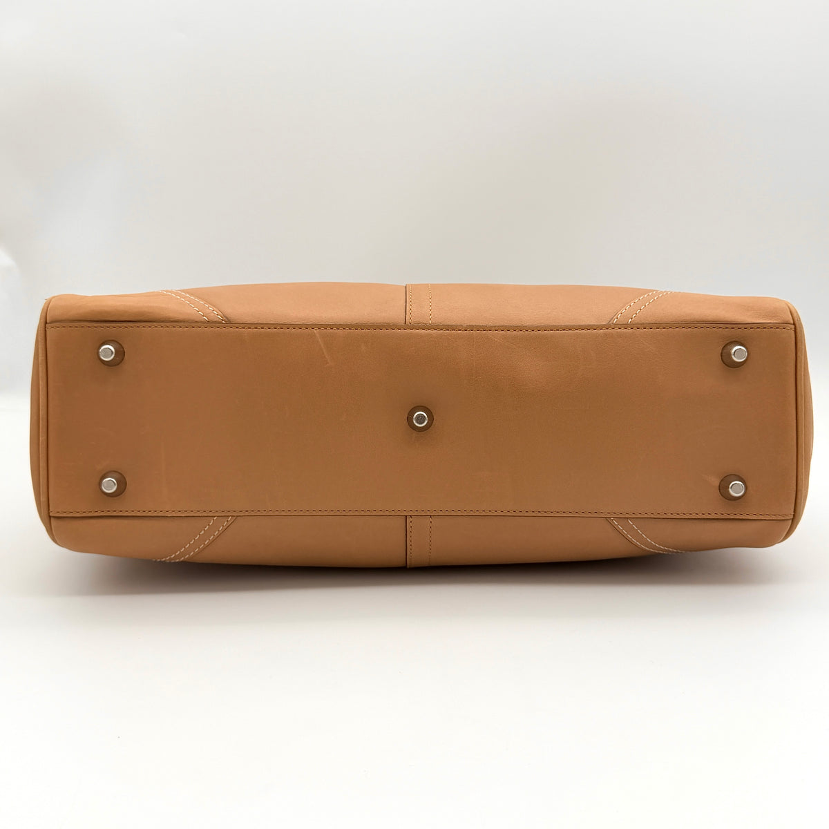 Coach Hampton Carryall in caramel brown leather with silver hardware and double handles, photographed against a white backdrop.