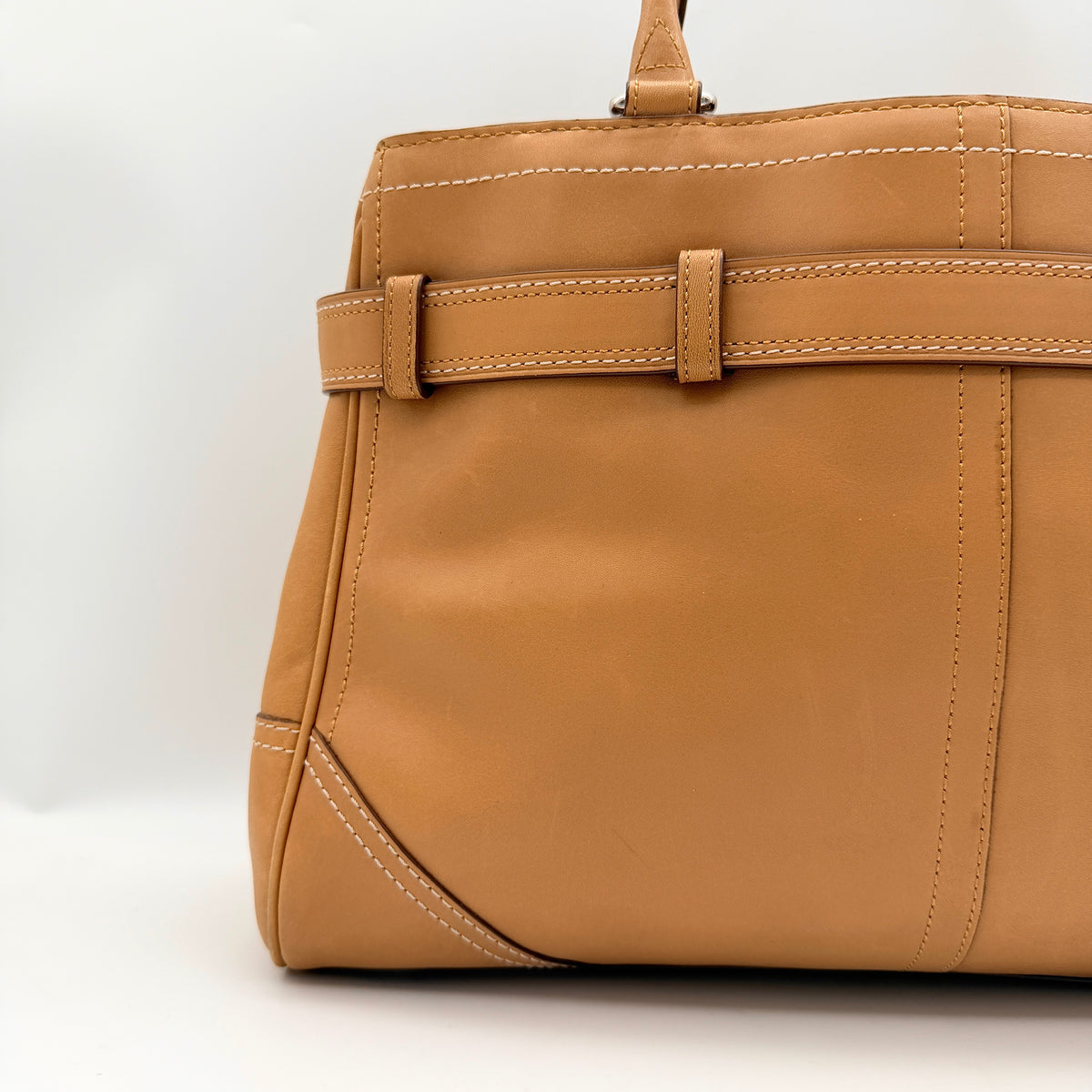 Coach Hampton Carryall in caramel brown leather with silver hardware and double handles, photographed against a white backdrop.