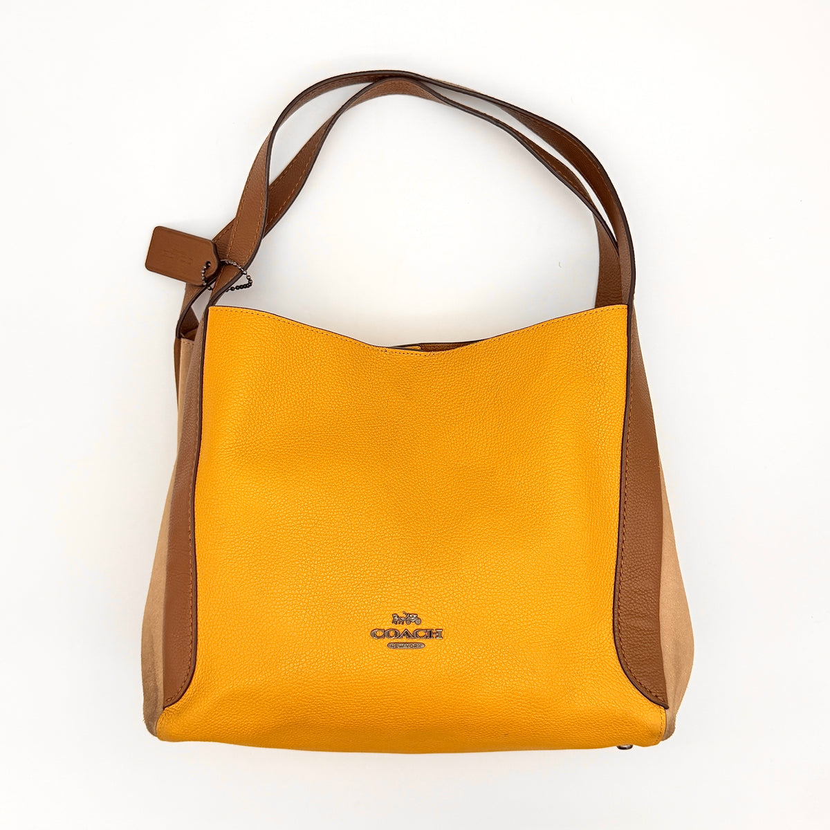 Coach Hadley Colorblock Hobo bag in yellow and brown leather with double top handles and suede side panels, shown against a white background.