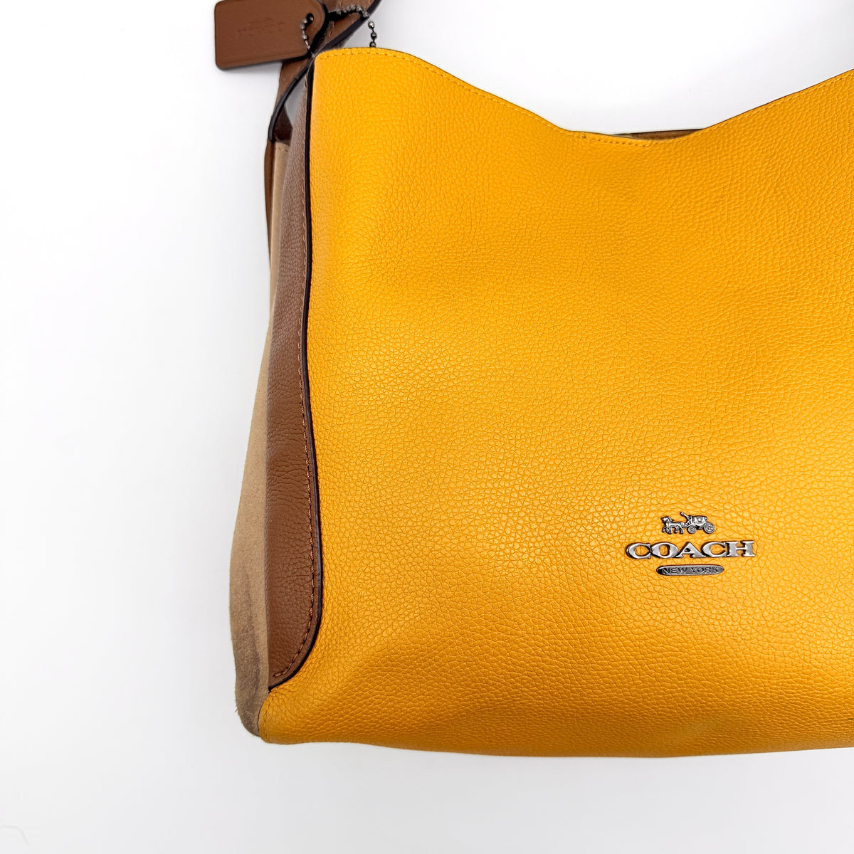 Coach Hadley Colorblock Hobo bag in yellow and brown leather with double top handles and suede side panels, shown against a white background.